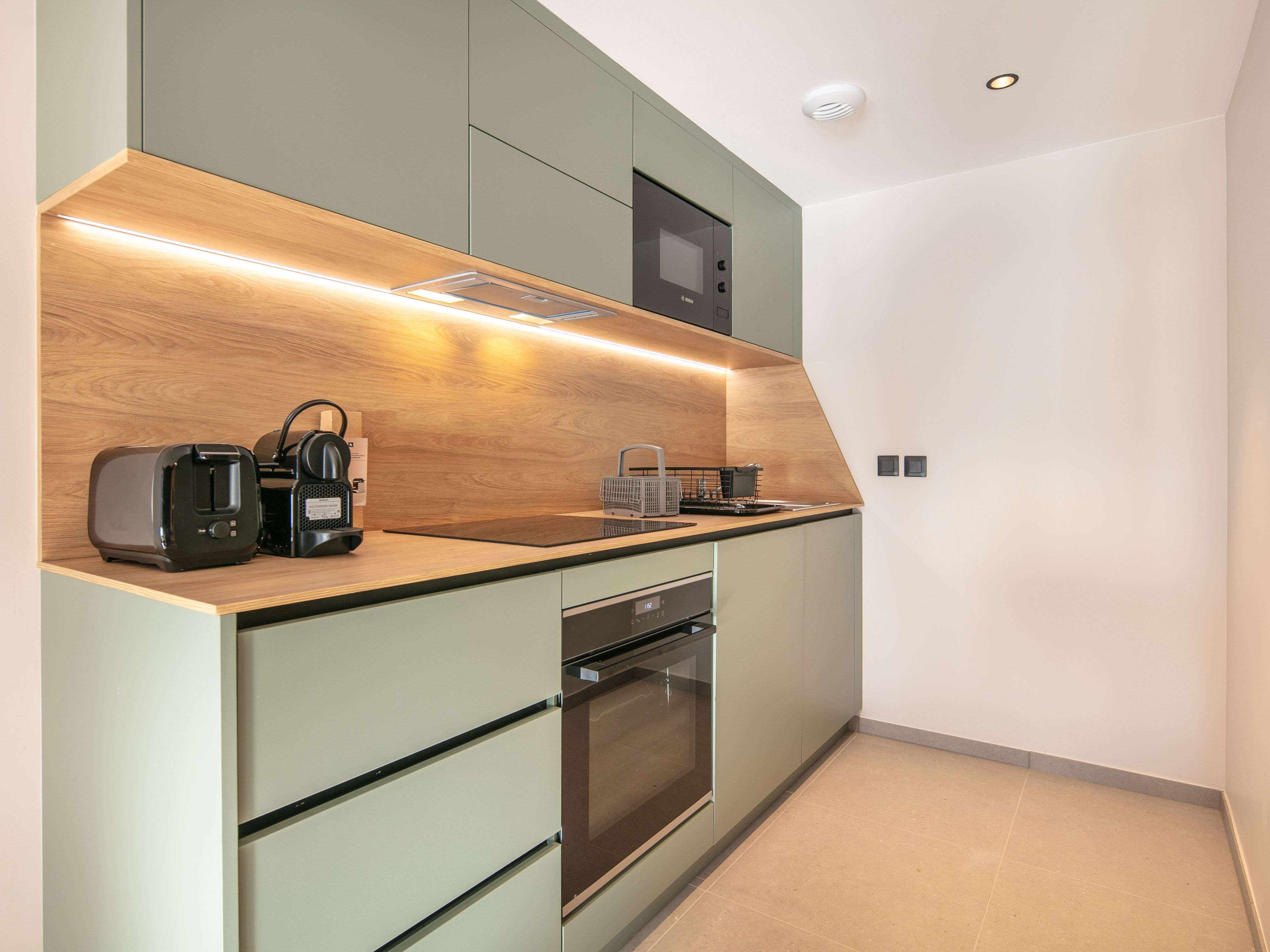 image Savor morning coffee in this sleek kitchenette, equipped with modern appliances for effortless meal prep.