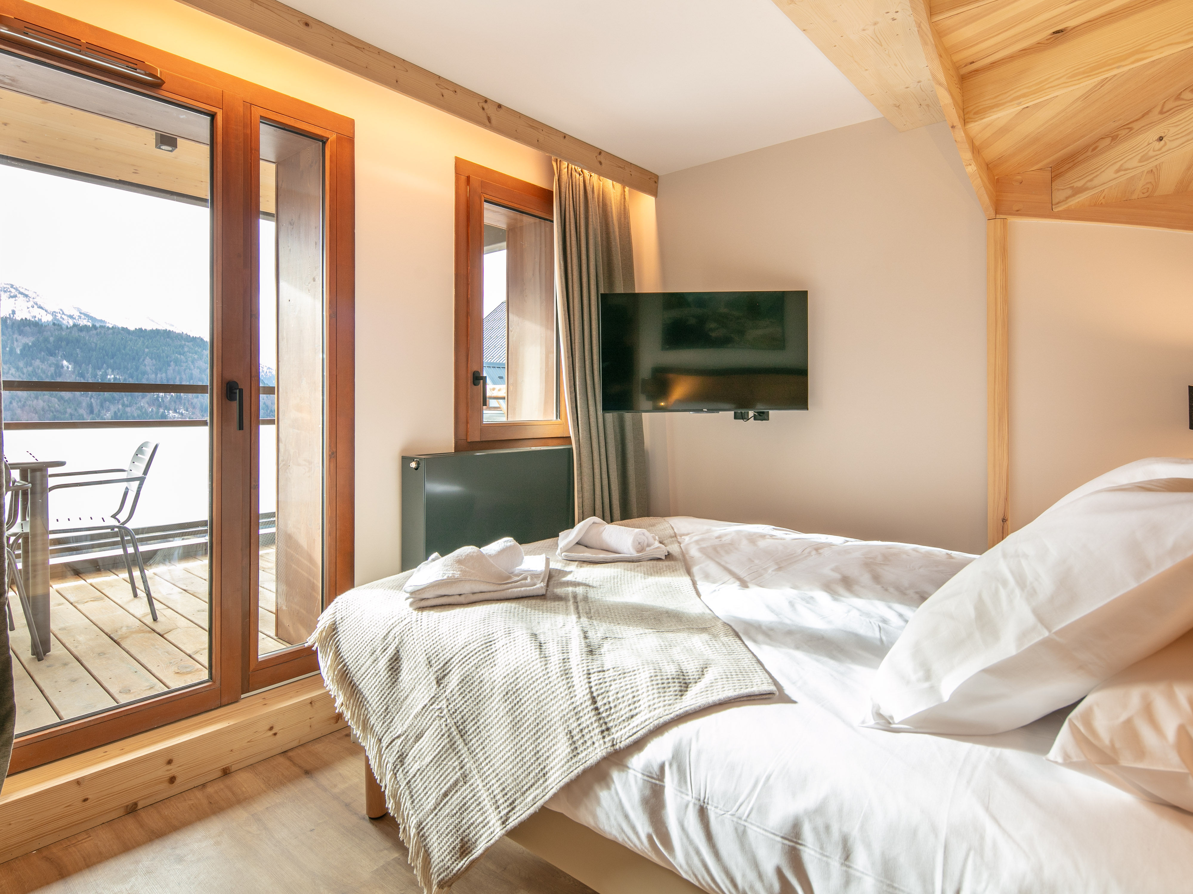 image Relax in the cozy bedroom, complete with natural wood accents and easy outdoor access.