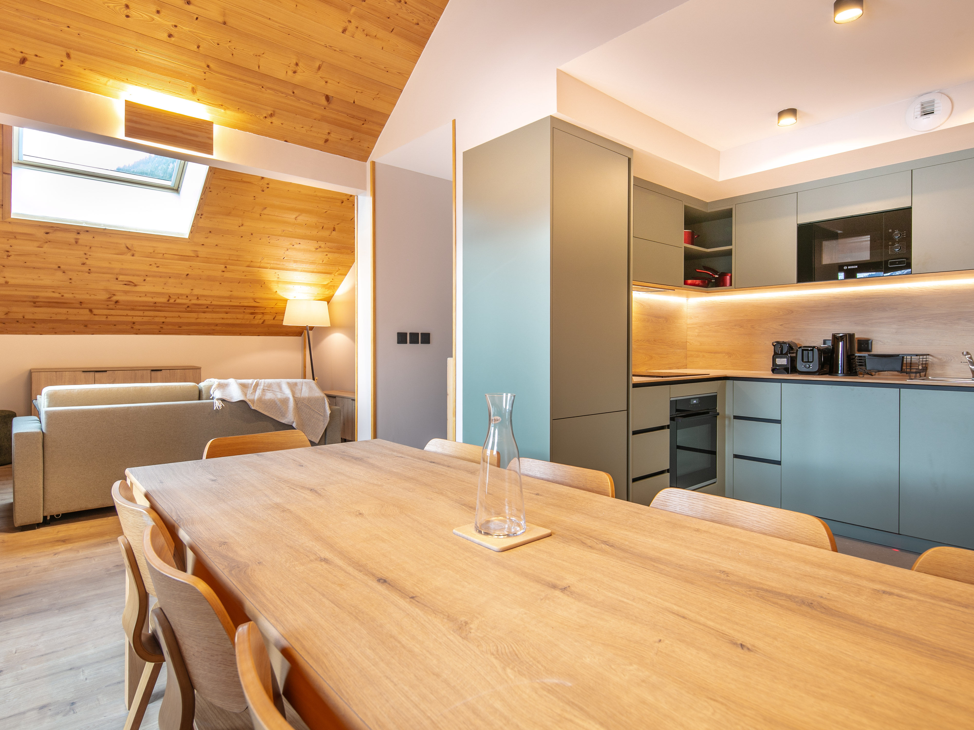 image Gather around the spacious dining table, where modern design meets rustic charm, perfect for shared meals.