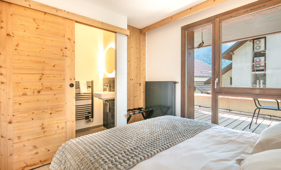 image The stylish bedroom features a cozy ambiance with natural wooden elements and an en-suite bathroom, ensuring a restful retreat.
