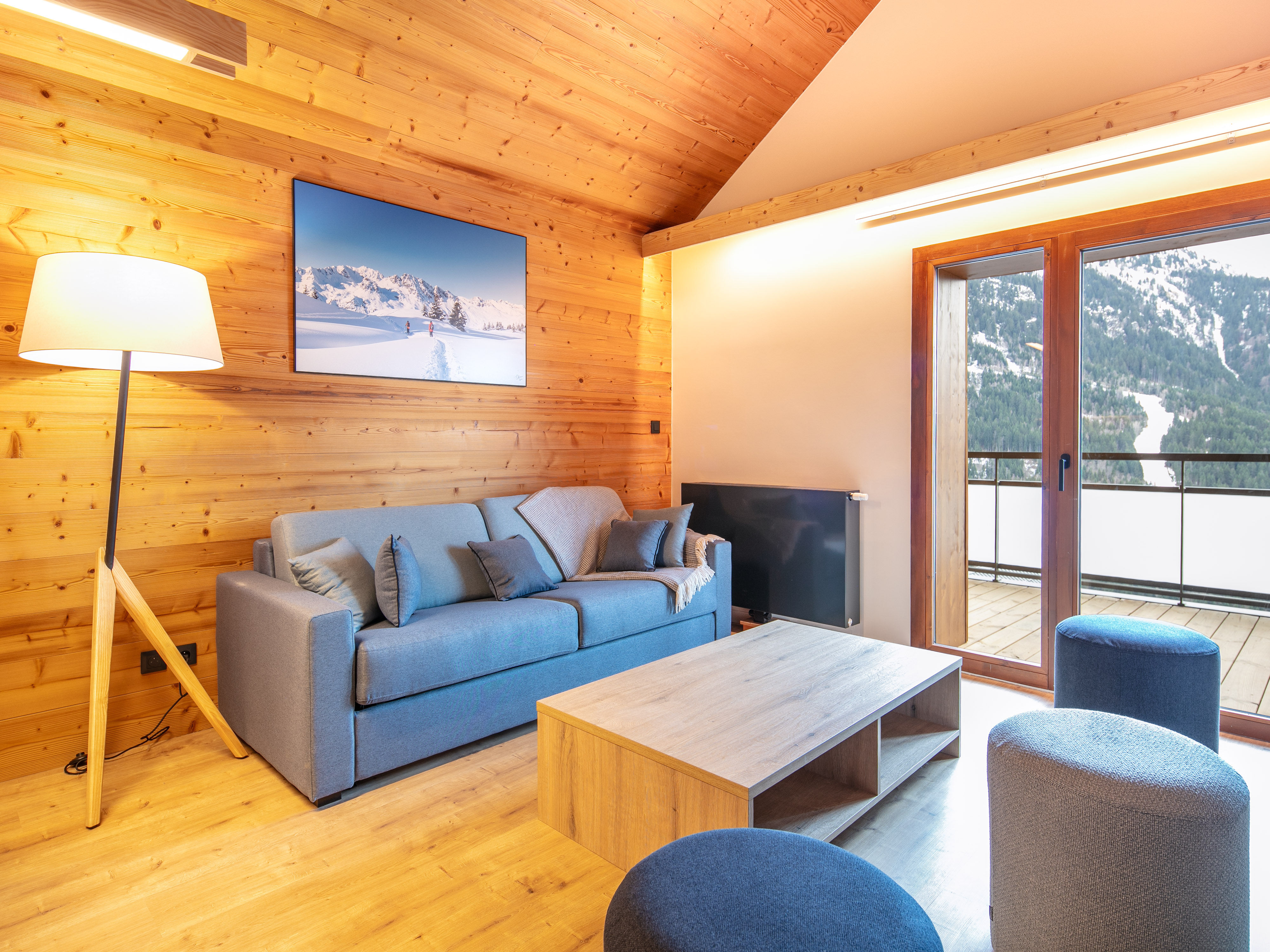 image Relax in the airy living space, where warm wood elements meet plush furnishings for ultimate comfort.