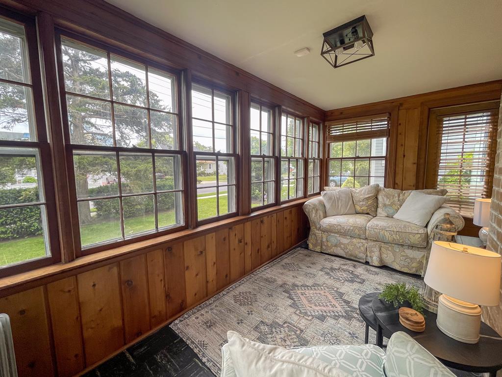 image A cozy echo of beach cottages past, this wood-paneled sitting room offers warmth and comfort after a day spent barefoot in the sand.