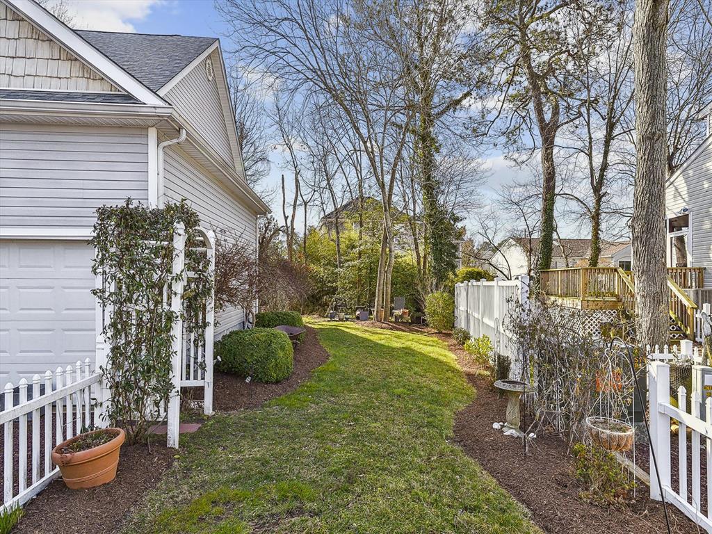 image A beautifully landscaped side yard enhances the home’s coastal charm with space for outdoor fun and family gatherings.