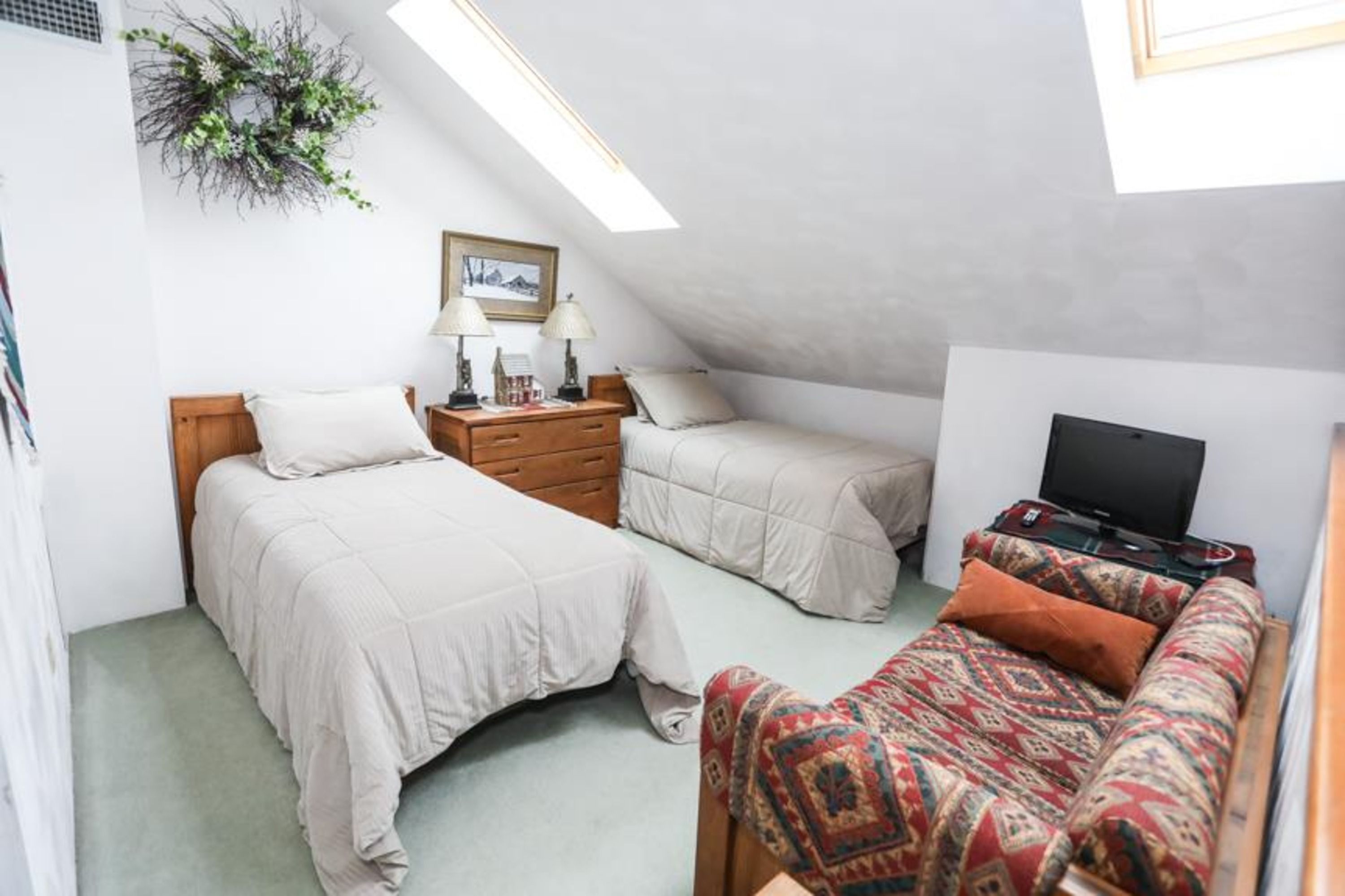 image Bright loft bedroom with two twin beds and its own full bathroom, ideal for kids or extra guests.