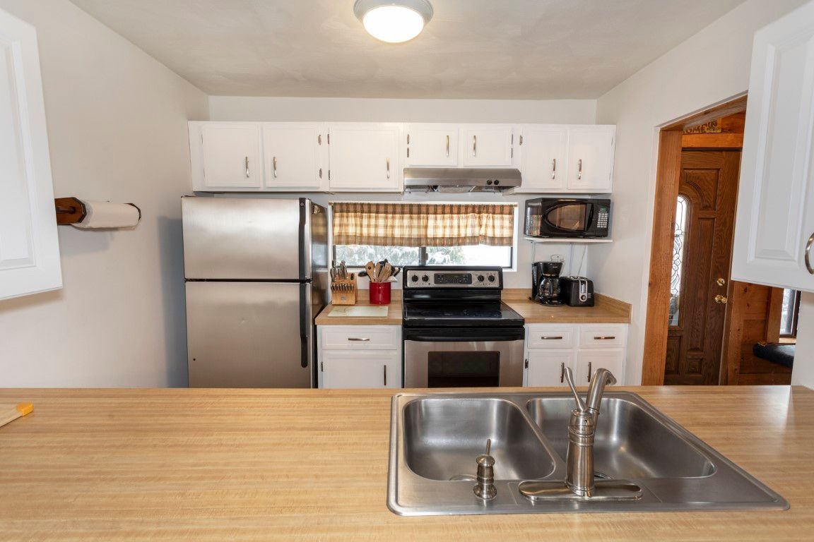 image Bright kitchen and spacious countertops create a welcoming space for gathering and meal prep.