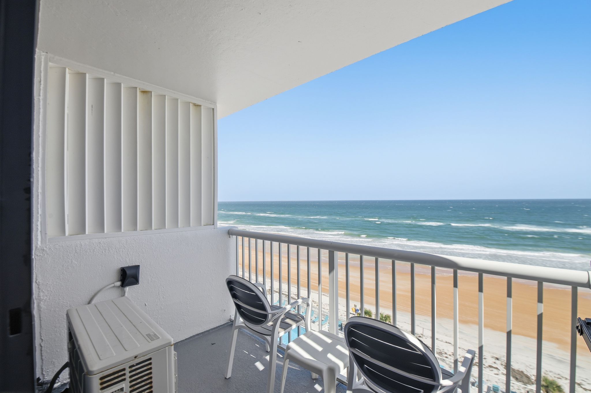 image Step onto the private balcony to savor the sea breeze, with breathtaking views of the sandy beach stretching beneath a brilliant blue sky.