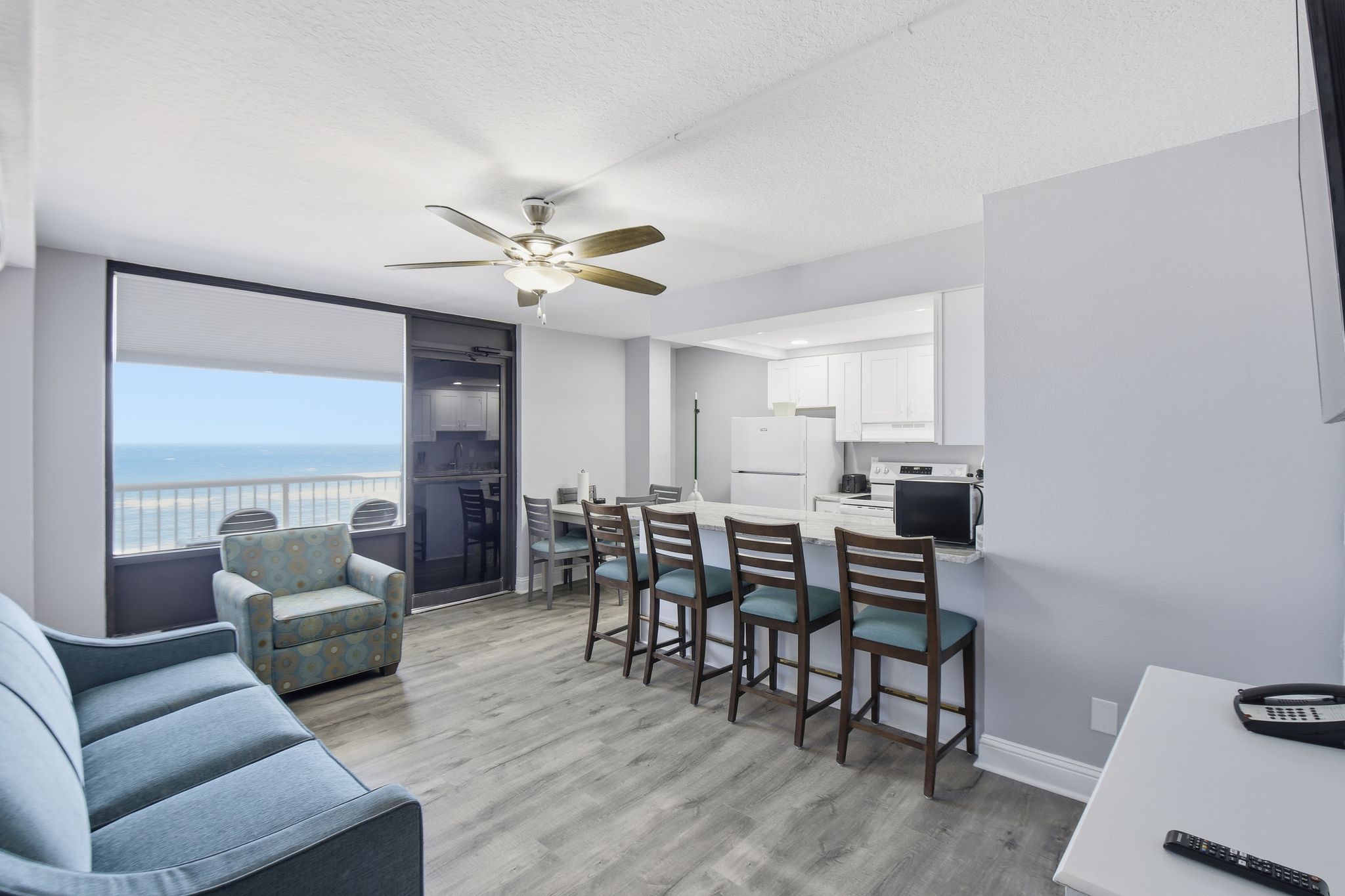 image Experience coastal elegance in the spacious Caribbean Room, where natural light floods the modern living area, highlighting the chic decor and inviting views of the Atlantic.