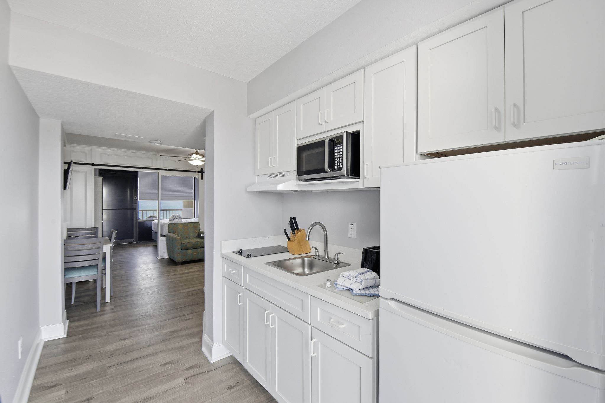image This modern kitchen is designed with white cabinetry and stainless steel appliances, including a stovetop, making meal preparation both efficient and enjoyable.