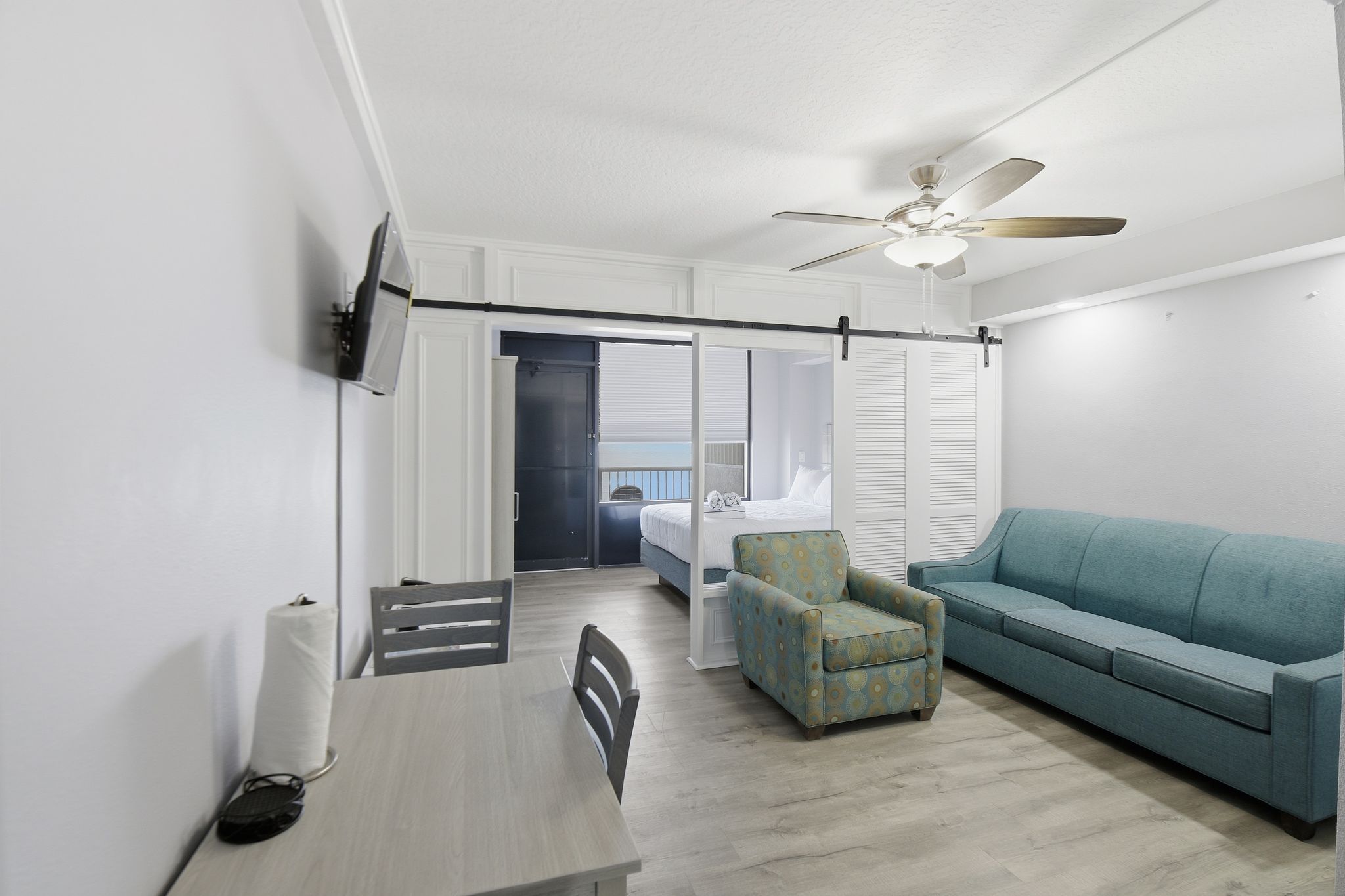 image This bright living space features comfortable furniture and artistic touches, while the large sliding barn door elegantly separates the sleeping and common areas for privacy.