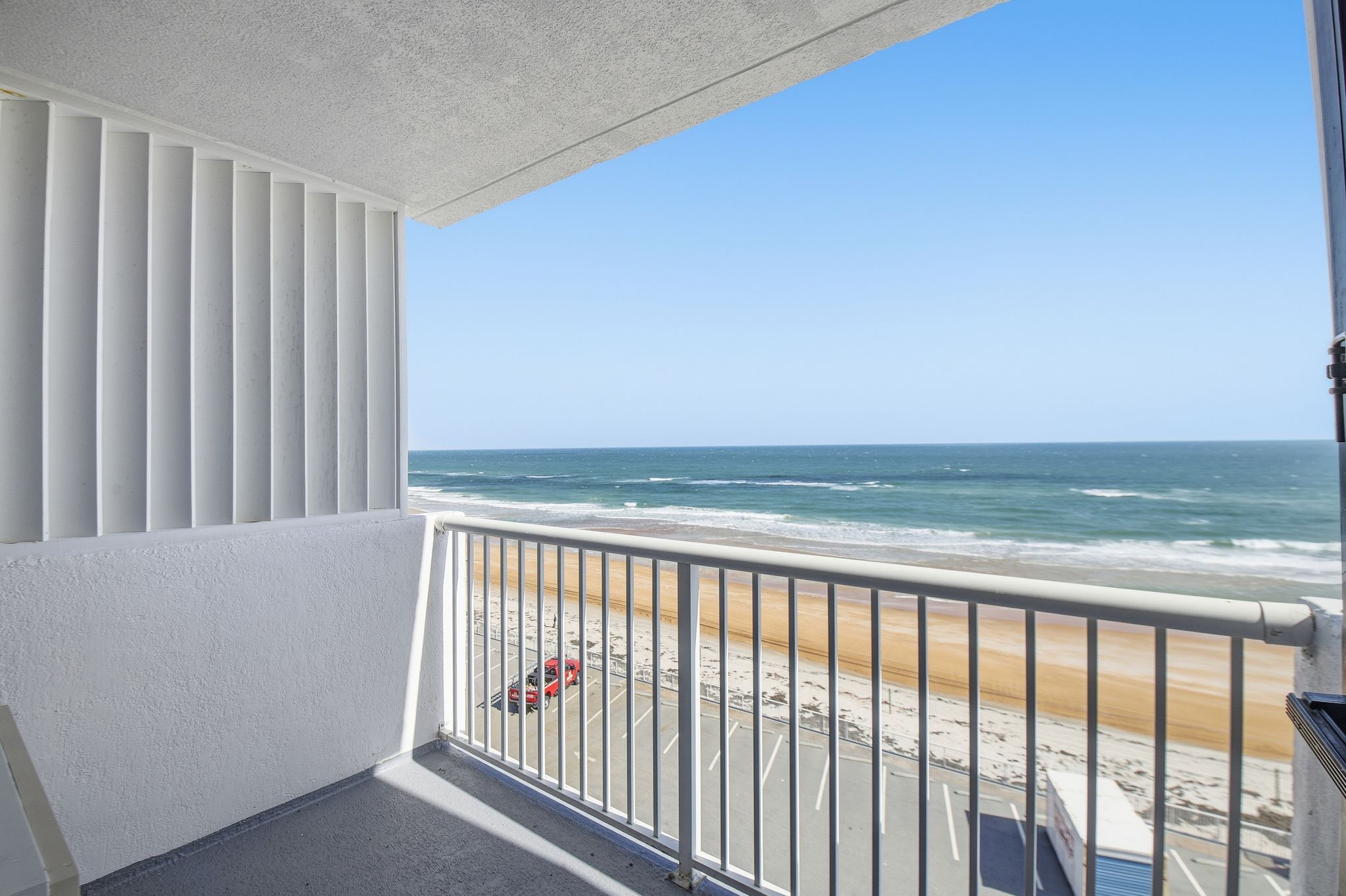 image Enjoy breathtaking views of the cerulean waves and golden sands from your private balcony, perfect for soaking in the sun and listening to the soothing sounds of the ocean.