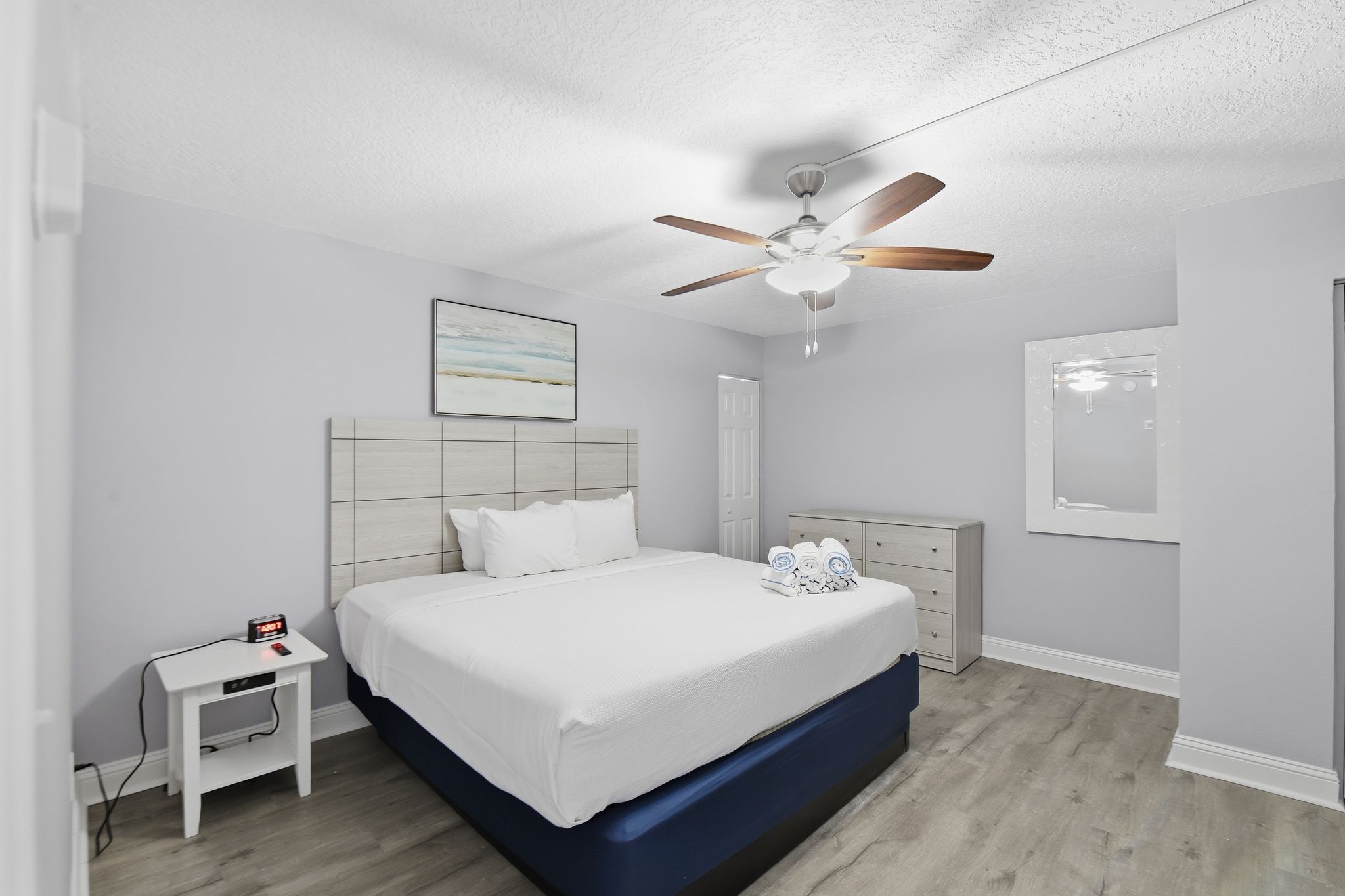 image The serene bedroom features a plush bed adorned with crisp linens, complemented by a ceiling fan and soft lighting, creating a tranquil retreat for restful nights.