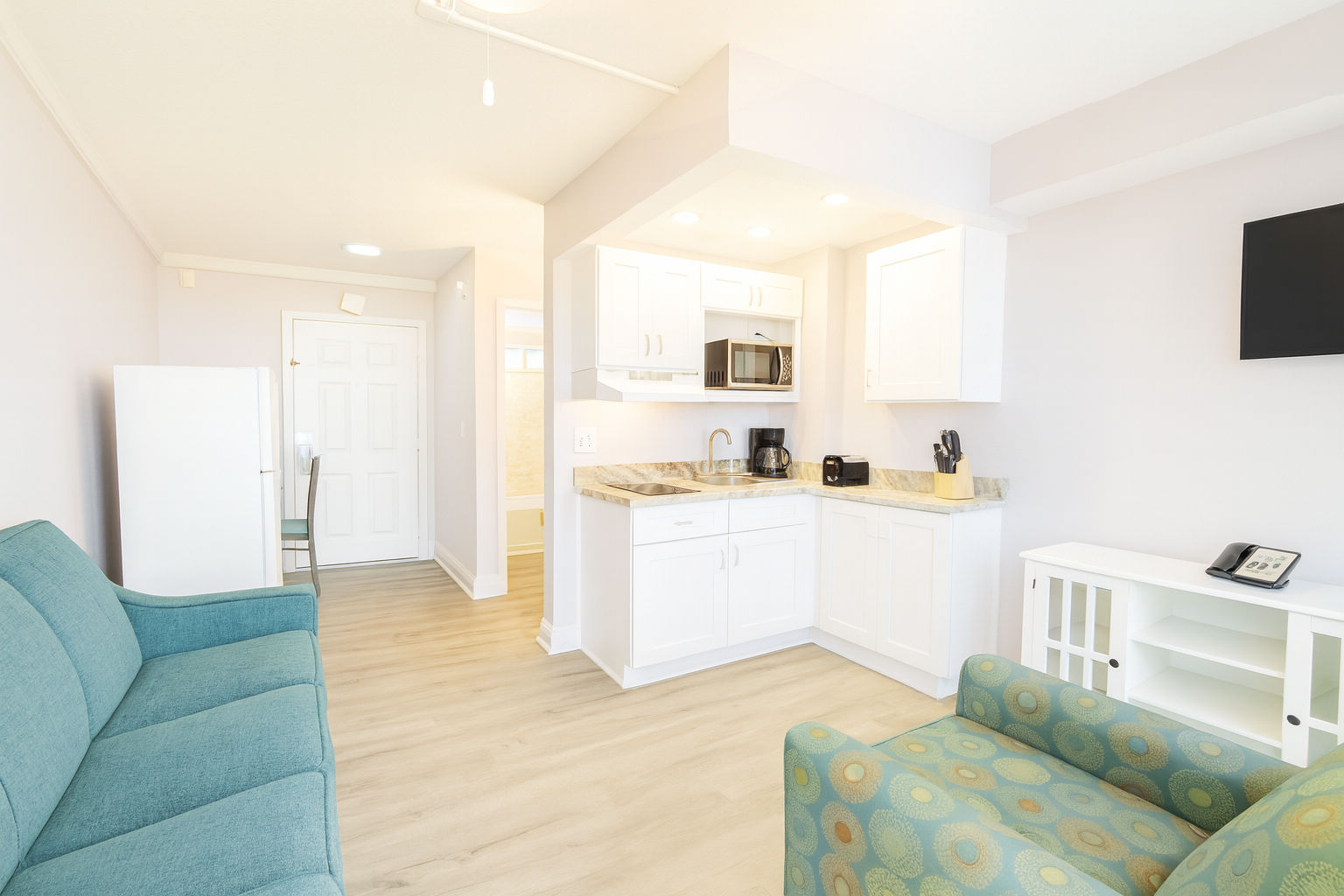 image A welcoming living space showcases a comfortable sofa and a functional kitchenette, ideal for family gatherings or a romantic getaway.