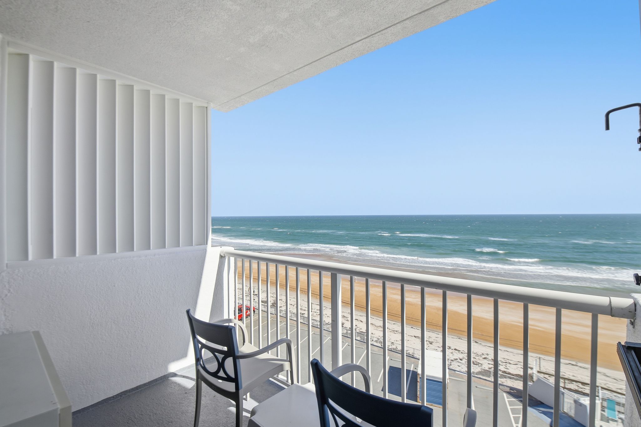 image Enjoy stunning ocean views from the private balcony, furnished with comfortable chairs, creating an ideal space for morning coffee or evening relaxation with the sound of waves crashing nearby.