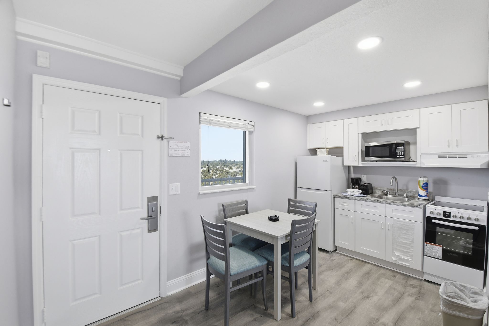 image A well-equipped kitchen boasts modern appliances and a dining table, perfect for enjoying home-cooked meals while overlooking scenic views through the window.