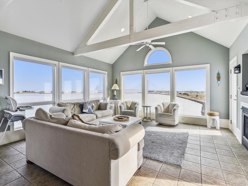image Comfortable living room with plush seating and expansive windows showcasing the waterfront.