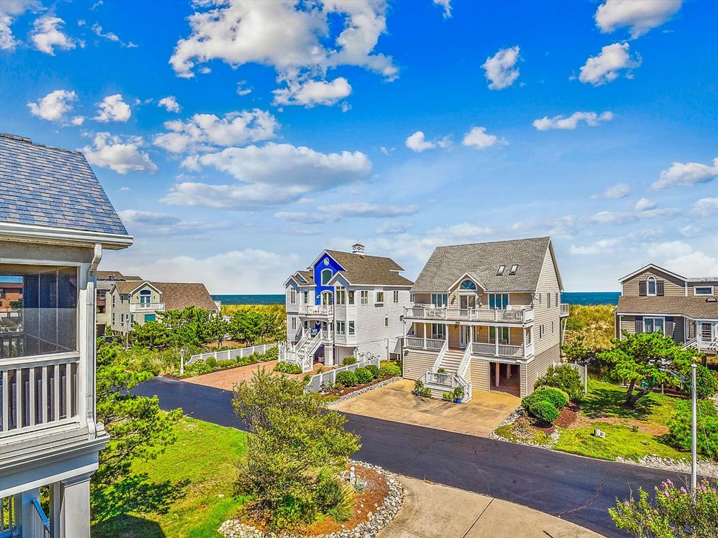 image The charming architecture of the coastal homes displays a delightful mix of colors and styles, all framed by manicured lawns and the serene backdrop of the beach.