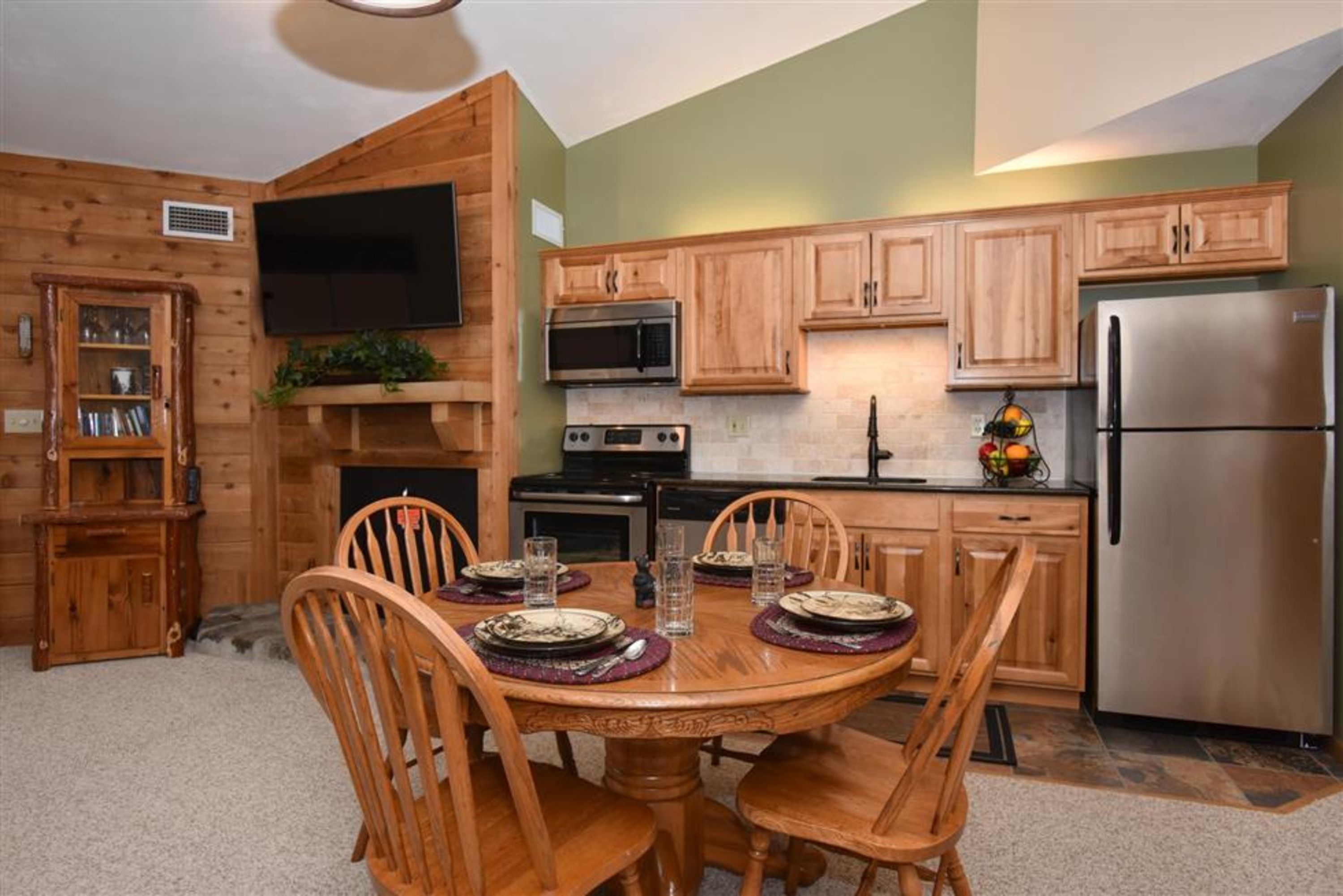 image Fully equipped kitchen with modern appliances and rustic charm, adjacent to a round dining table for four.