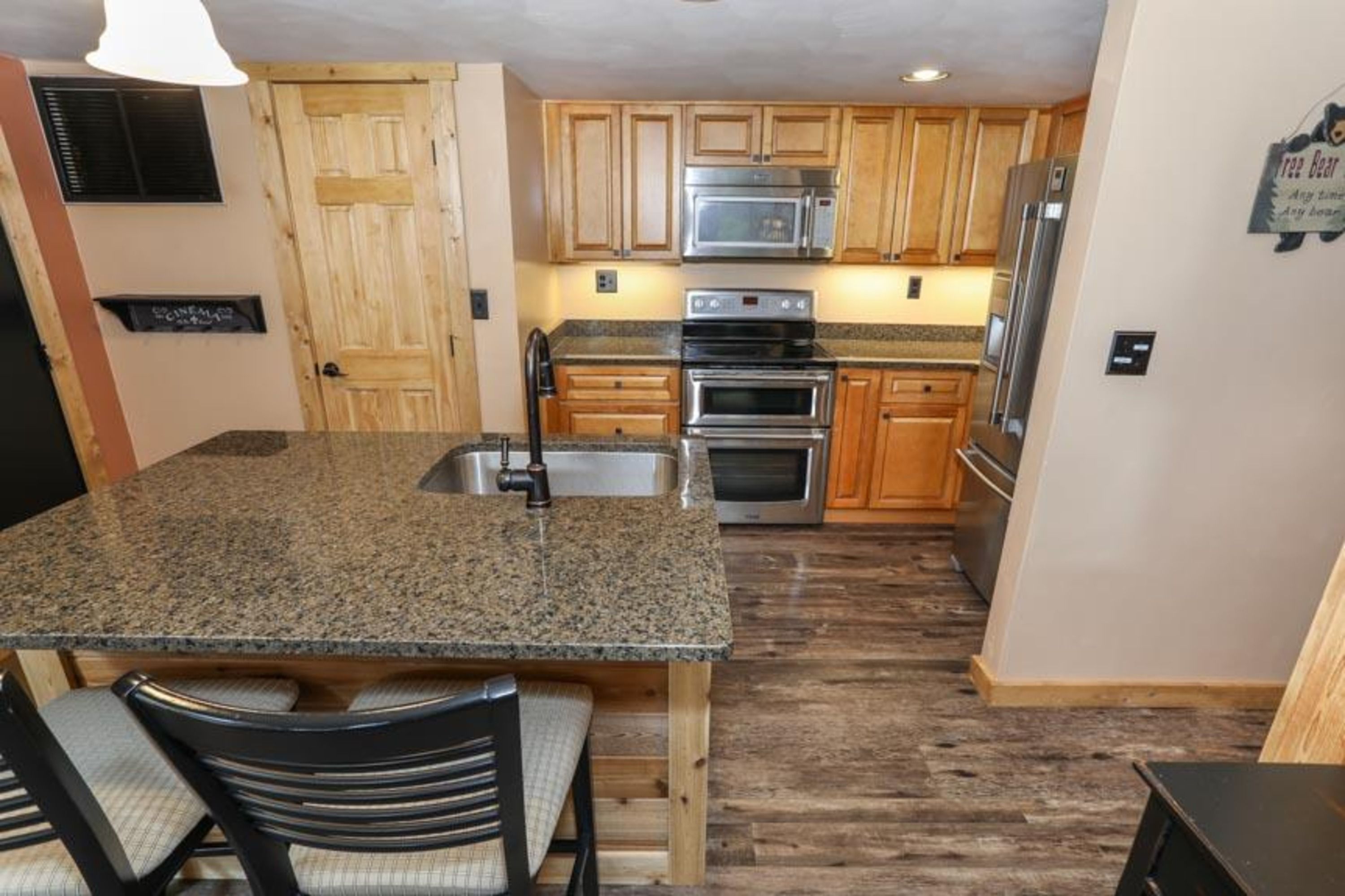 image Rustic-modern kitchen fully equipped with appliances and a granite island for easy meal prep.