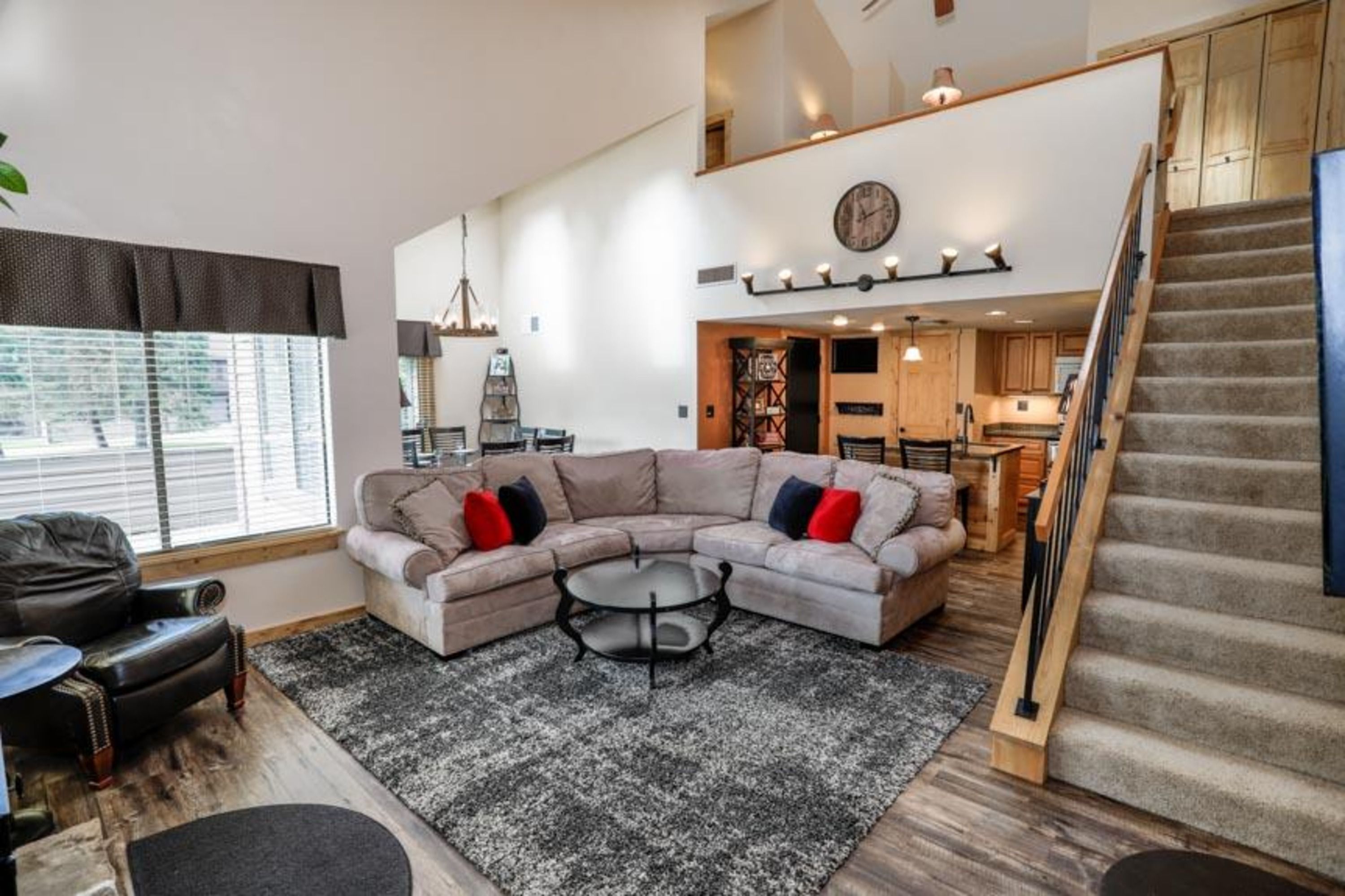 image Inviting living room with electric fireplace, plush sectional, and vaulted ceilings for cozy nights in.