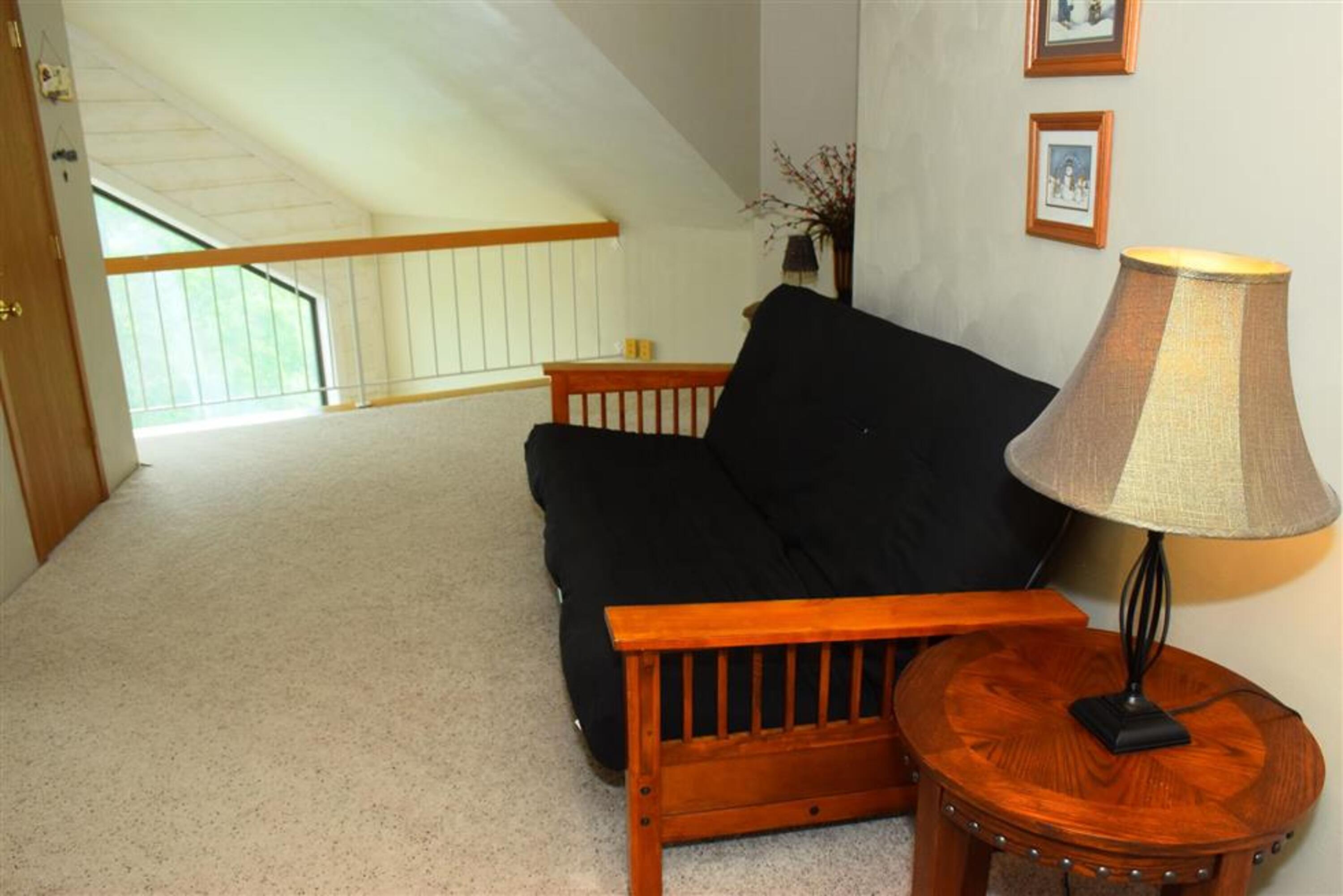 image Open loft area with a comfy futon, ideal for lounging or extra sleeping space.