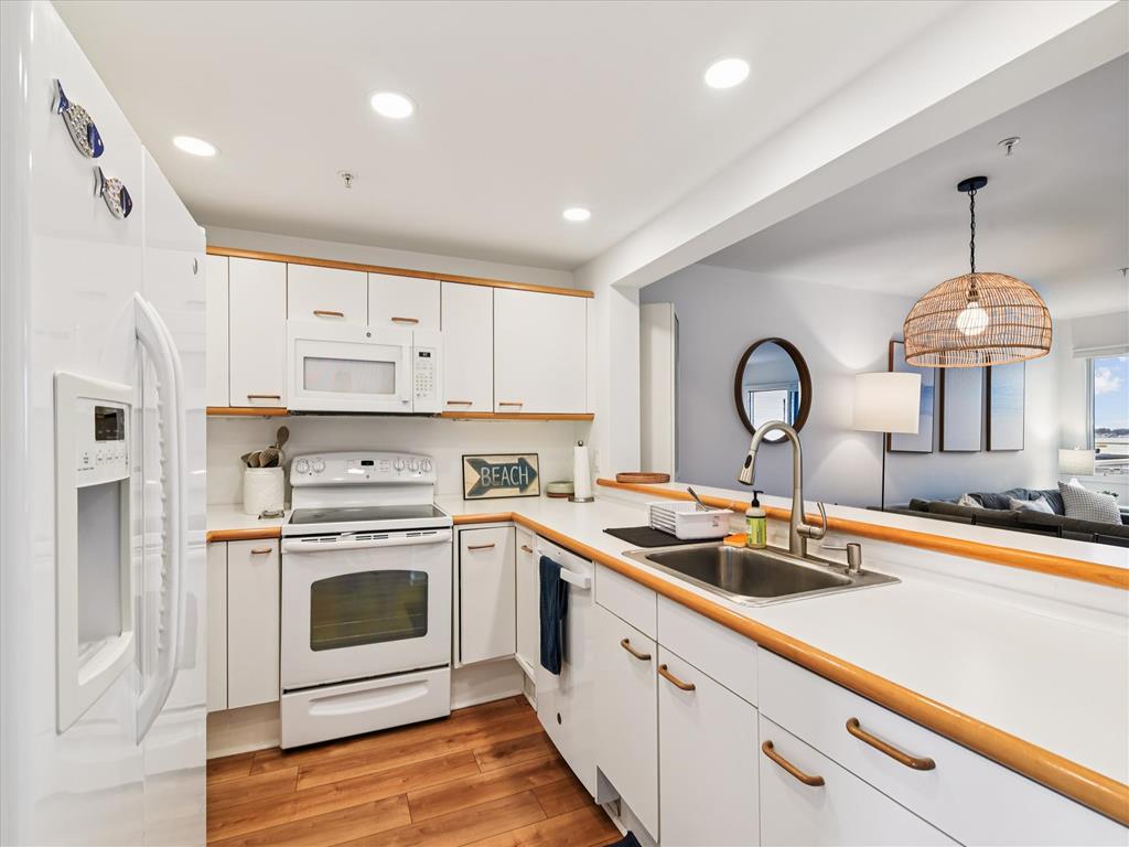 image The bright and airy kitchen features modern appliances and a cozy beach-inspired decor, perfect for family meals and gatherings.