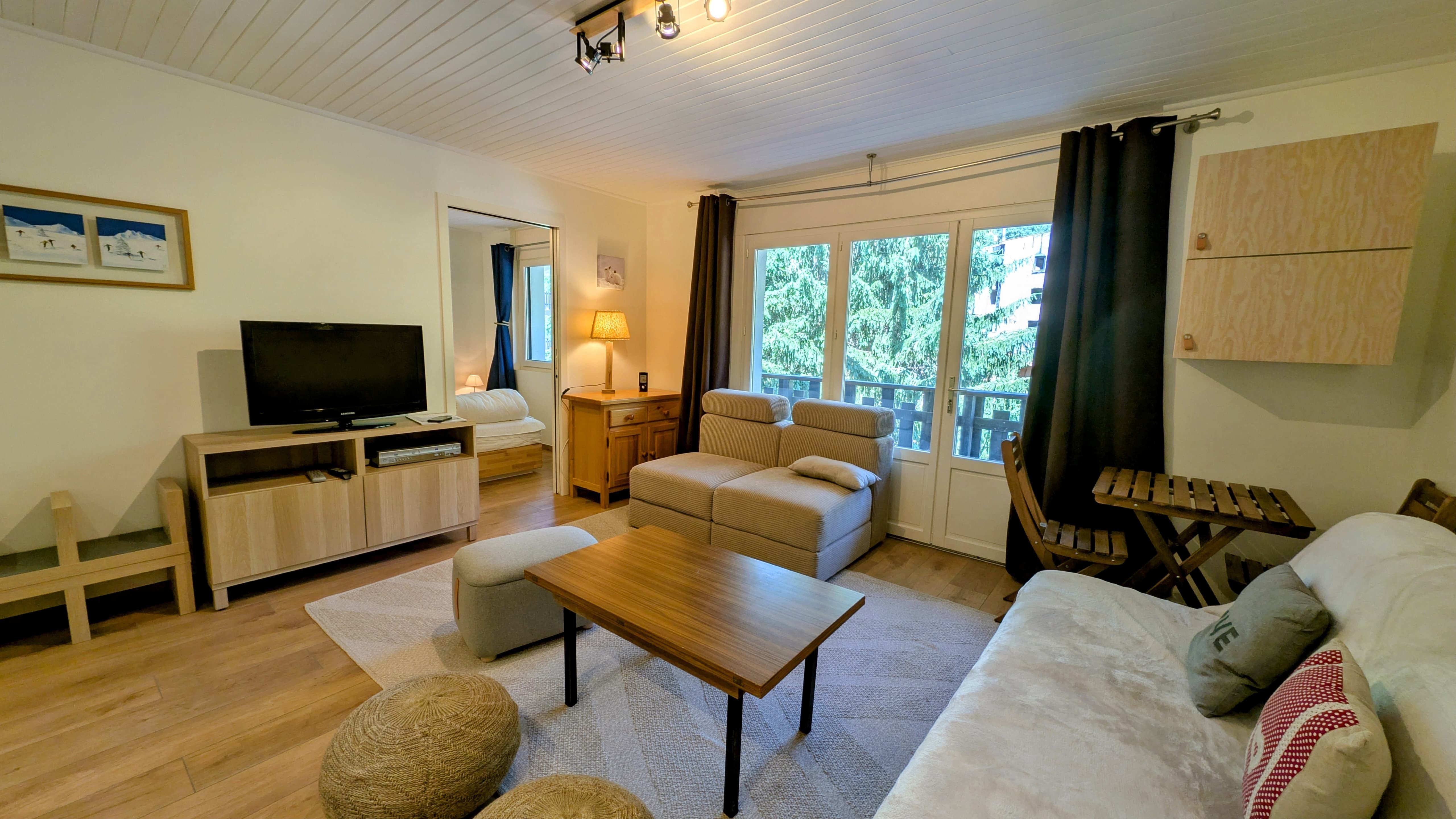image Bright and cozy living room with natural light, smart TV, and direct access to the balcony.