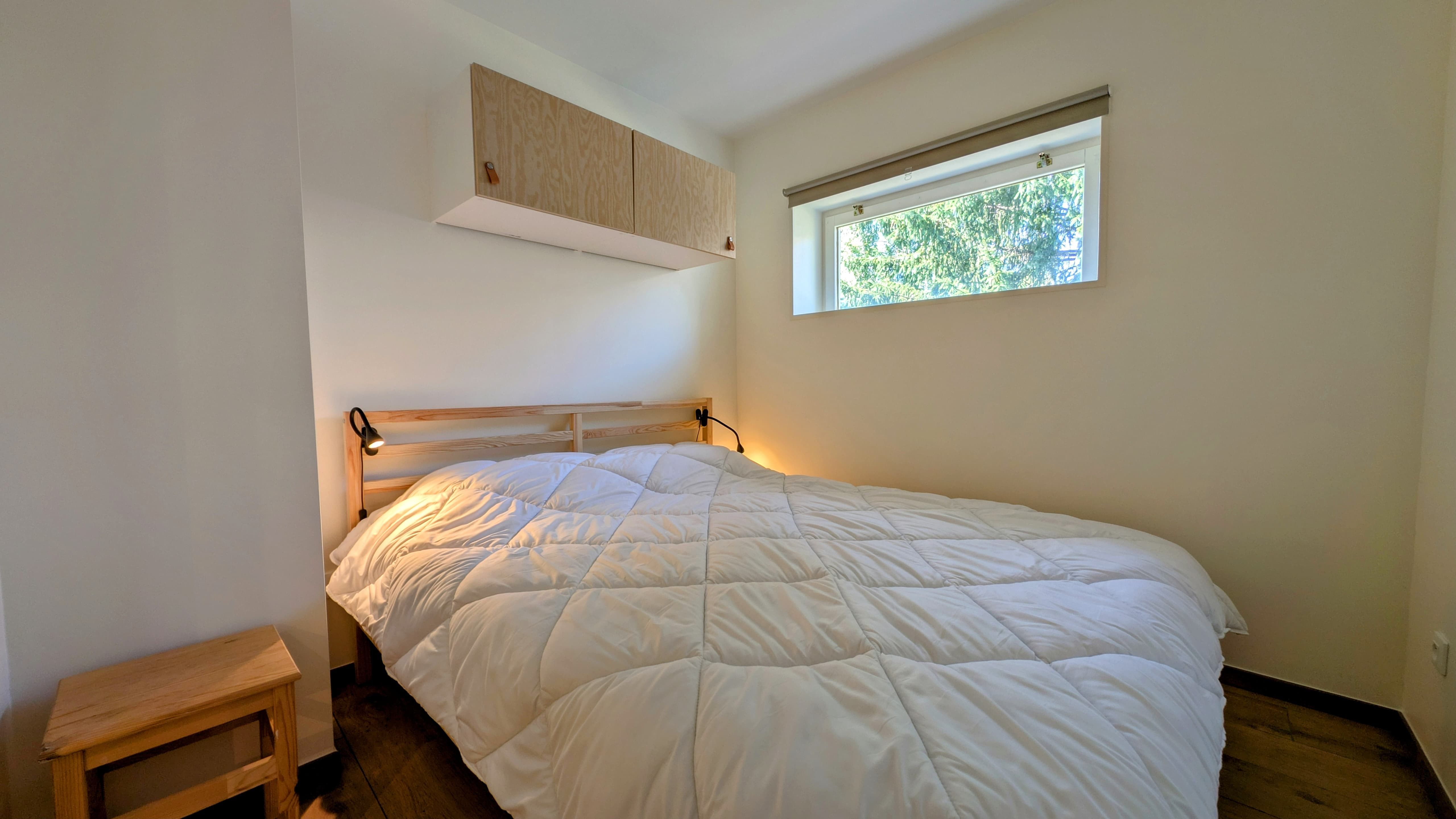 image Comfortable double bedroom with soft lighting and a peaceful view for restful nights in the mountains.