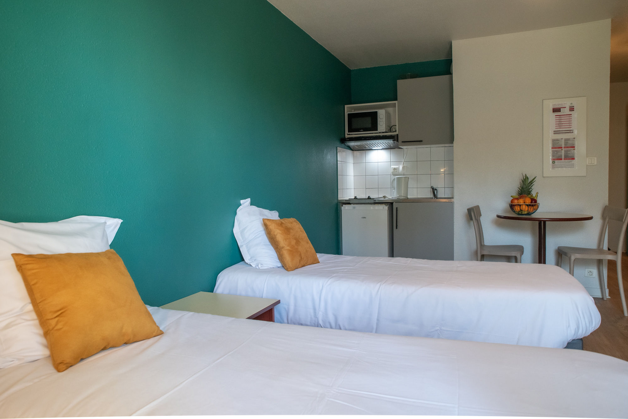 image A bright studio layout with twin beds and an open living area for a comfortable stay.