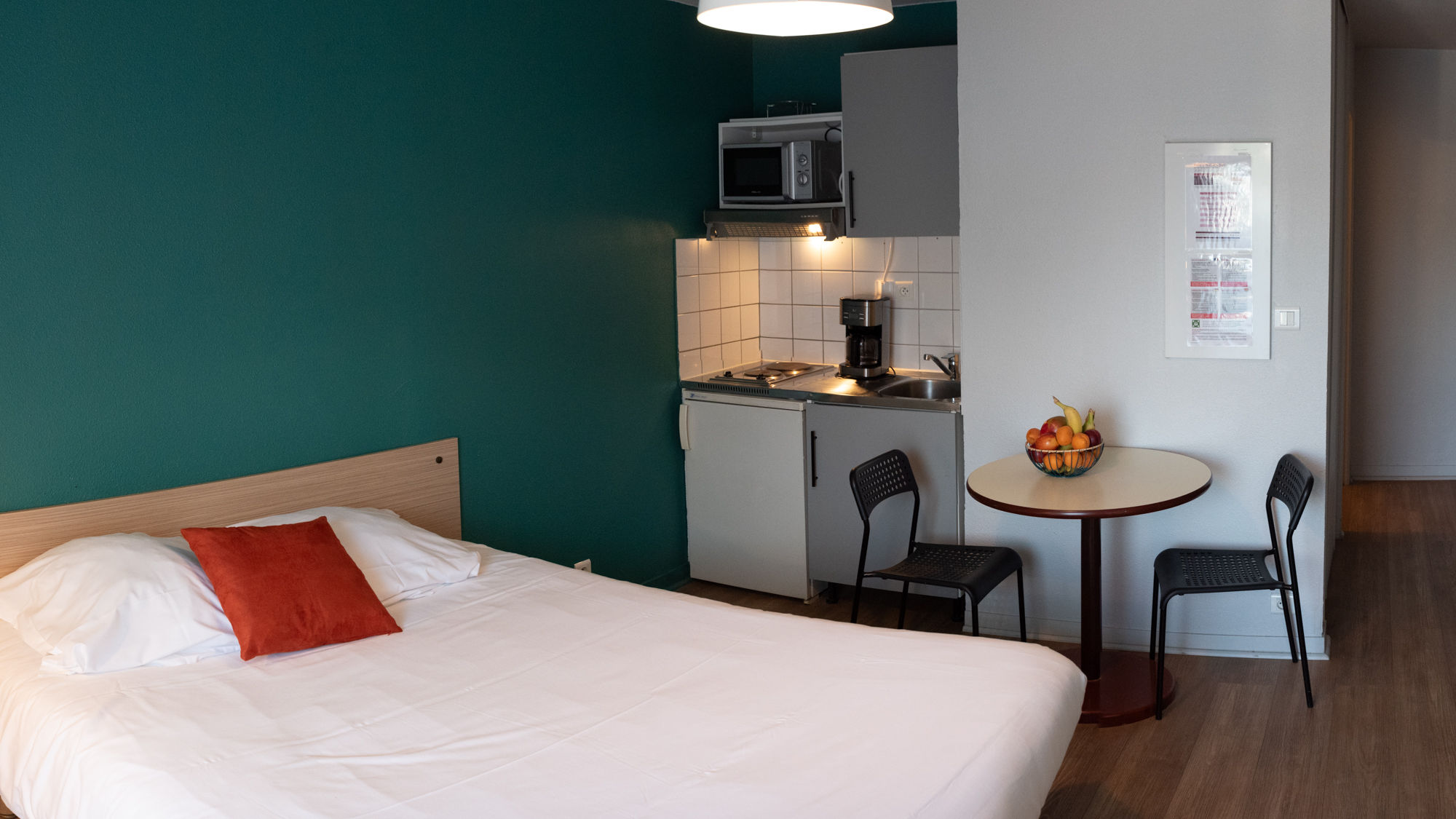 image A bright studio layout that combines sleeping and dining space in a comfortable, open setting.