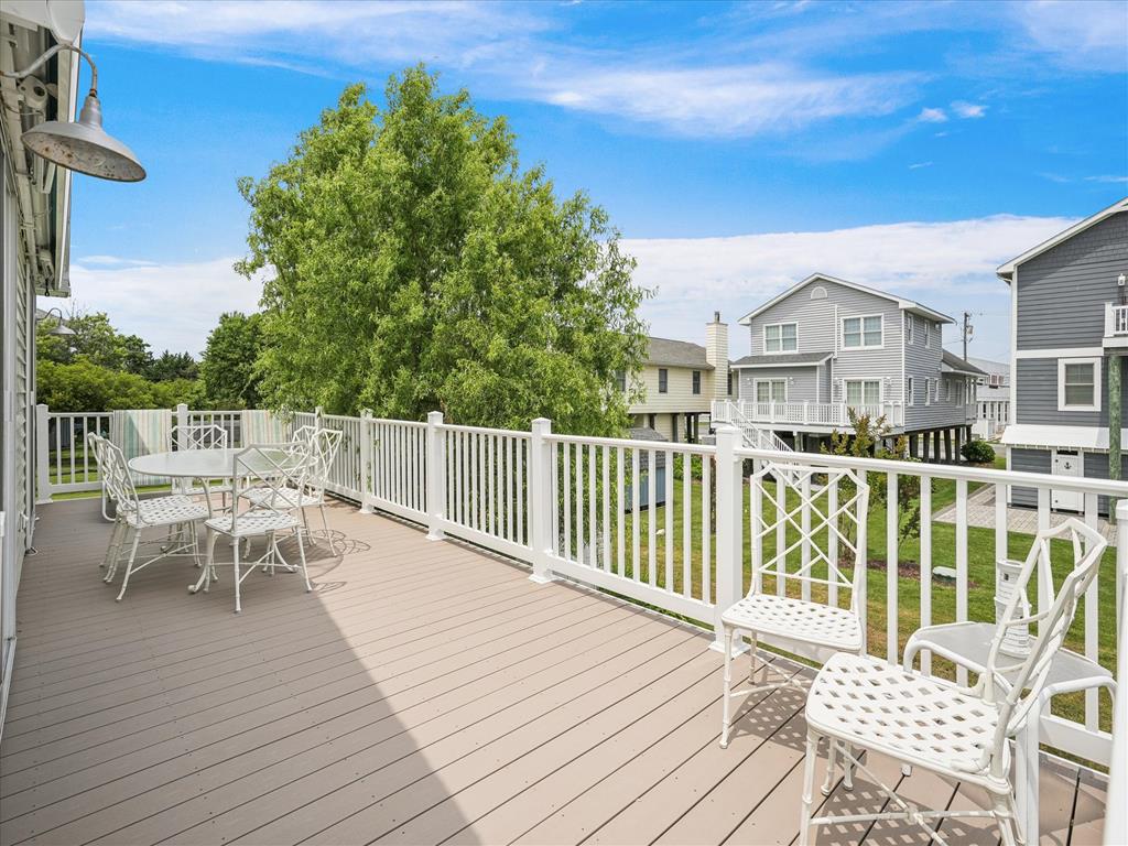 image Expansive outdoor deck ideal for relaxing or entertaining, surrounded by lush greenery and a tranquil beach atmosphere.