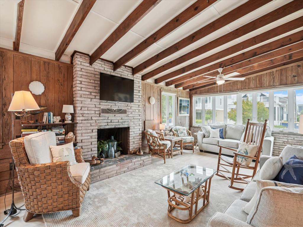 image The spacious living area boasts high wooden beams and a fireplace, creating a warm atmosphere for family and friends to gather.