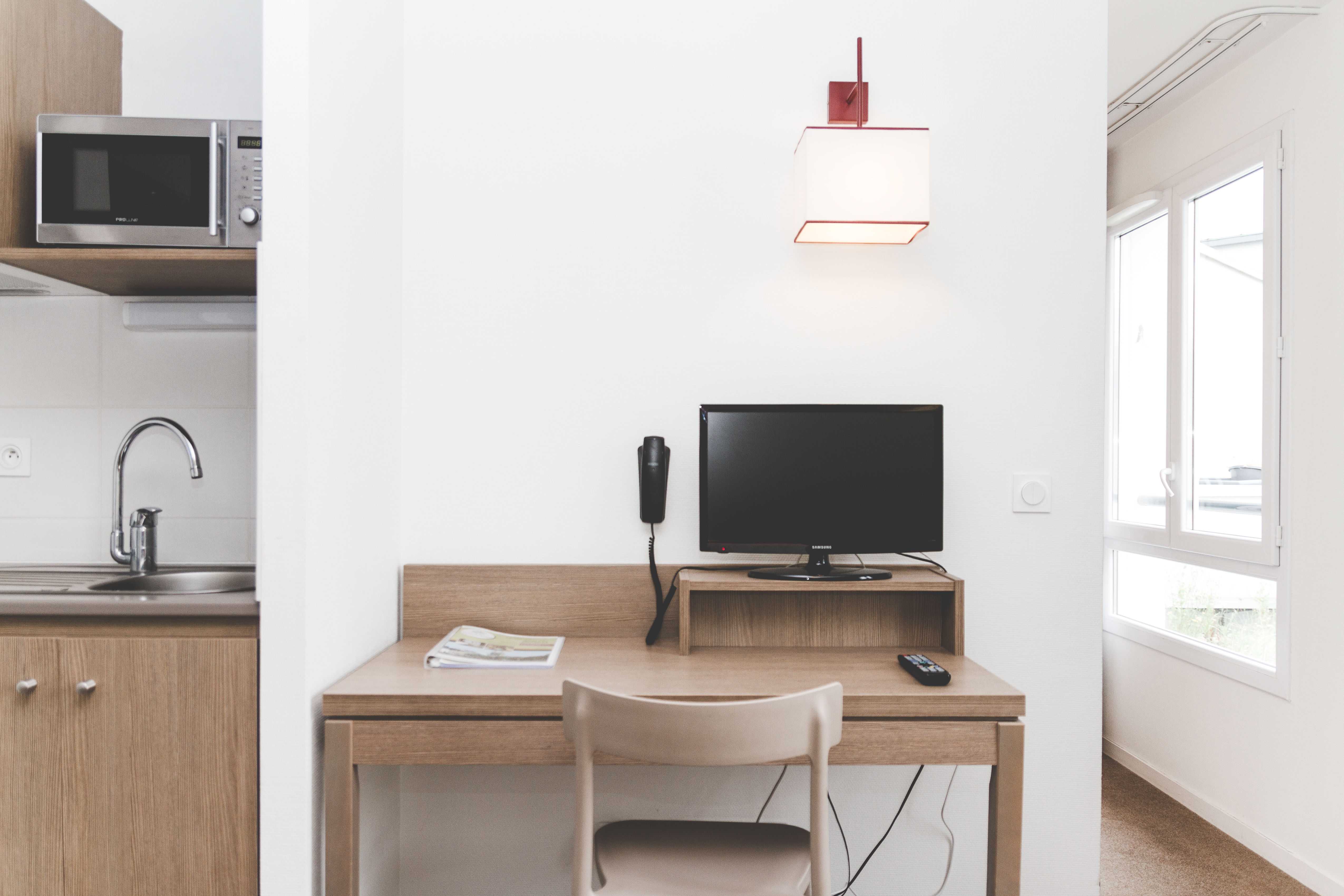 image A practical desk sits beside the kitchenette, offering a bright space for work or planning the day.