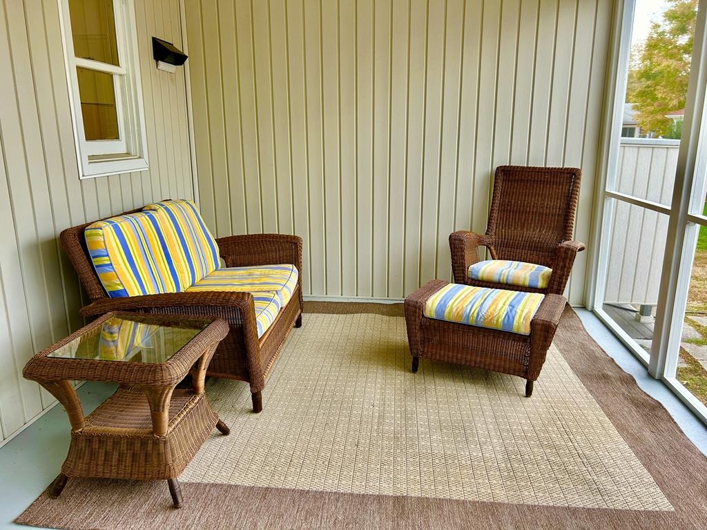 image Sink into leisure on the screened porch, featuring soft cushions and a perfect spot for reading or sipping coffee.