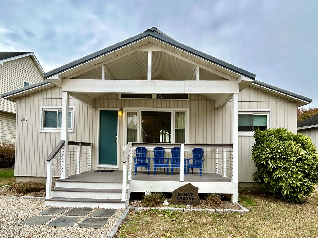 image Step onto the inviting porch with vibrant blue chairs, perfect for gathering after a day at the beach.