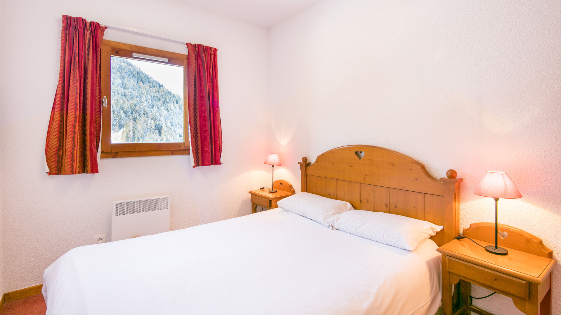 image Comfortable double bedroom with warm wooden décor and soft lighting for restful alpine nights.