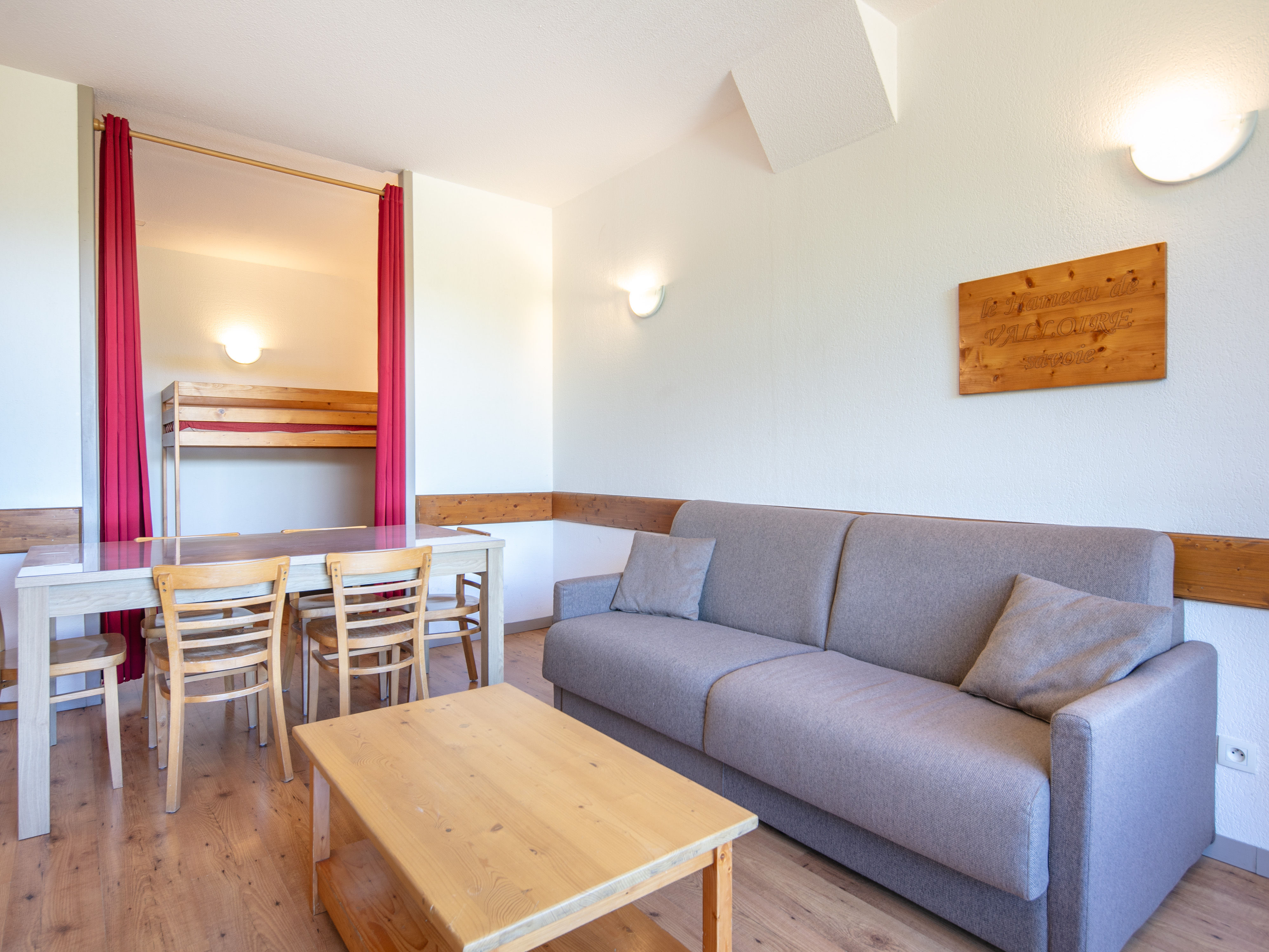 image Bright and spacious living area with cozy sofa and dining table, ideal for unwinding after a day in the Alps.