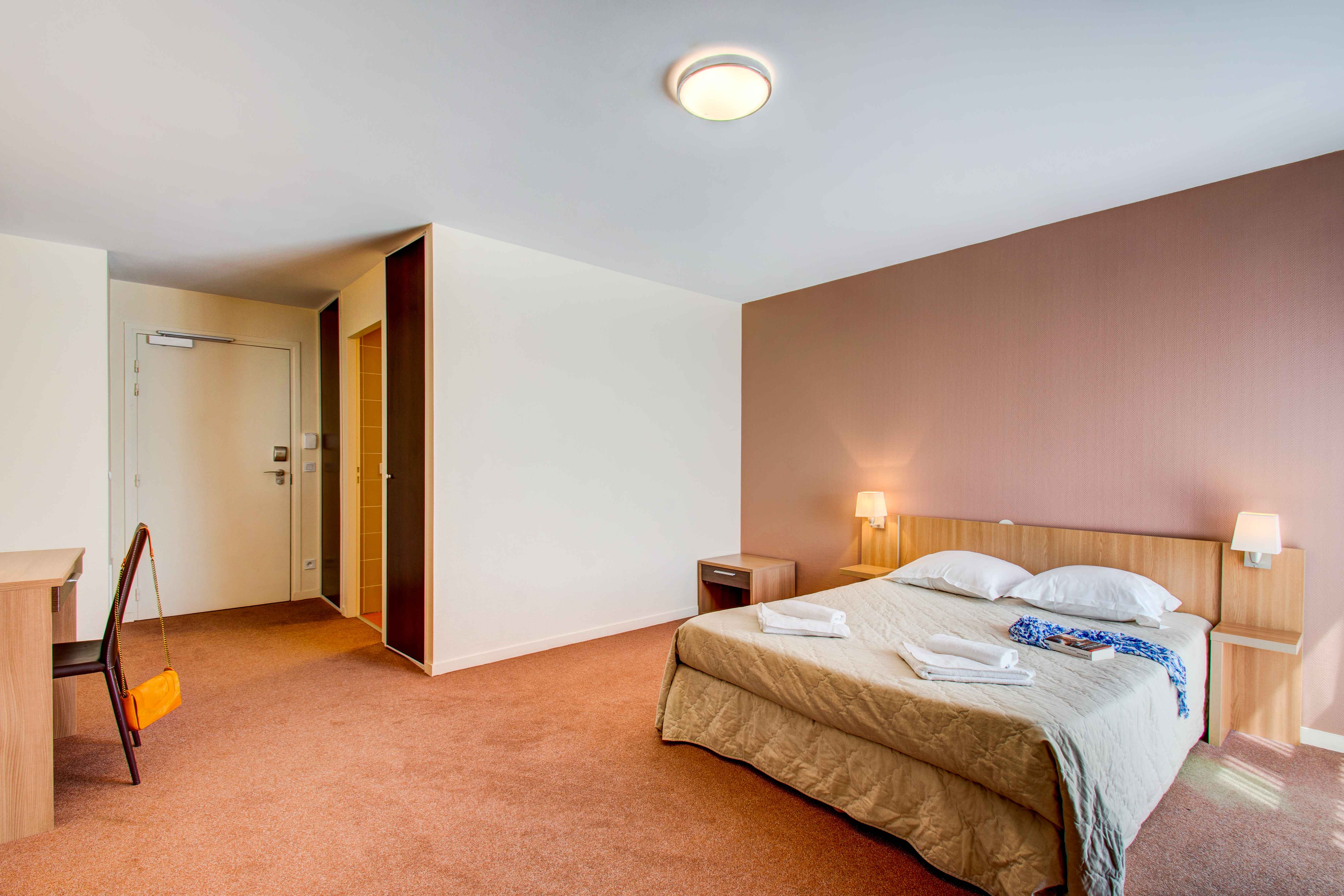 image Spacious and well-lit double room featuring a separable double bed, cozy decor, and warm tones for a relaxing stay.
