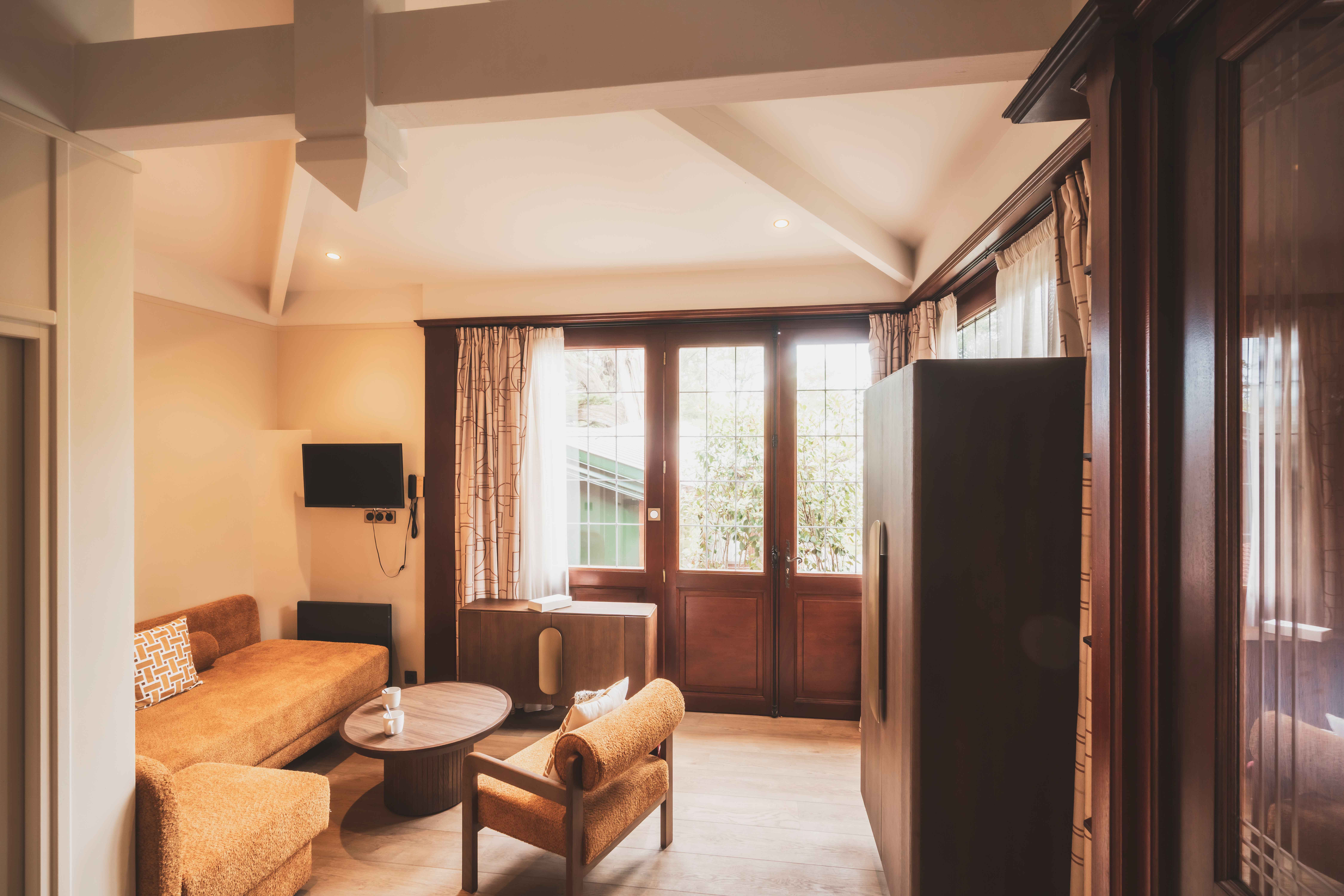 image Sunlight streams through wide windows, blending indoor comfort with the lush calm of the surrounding park.