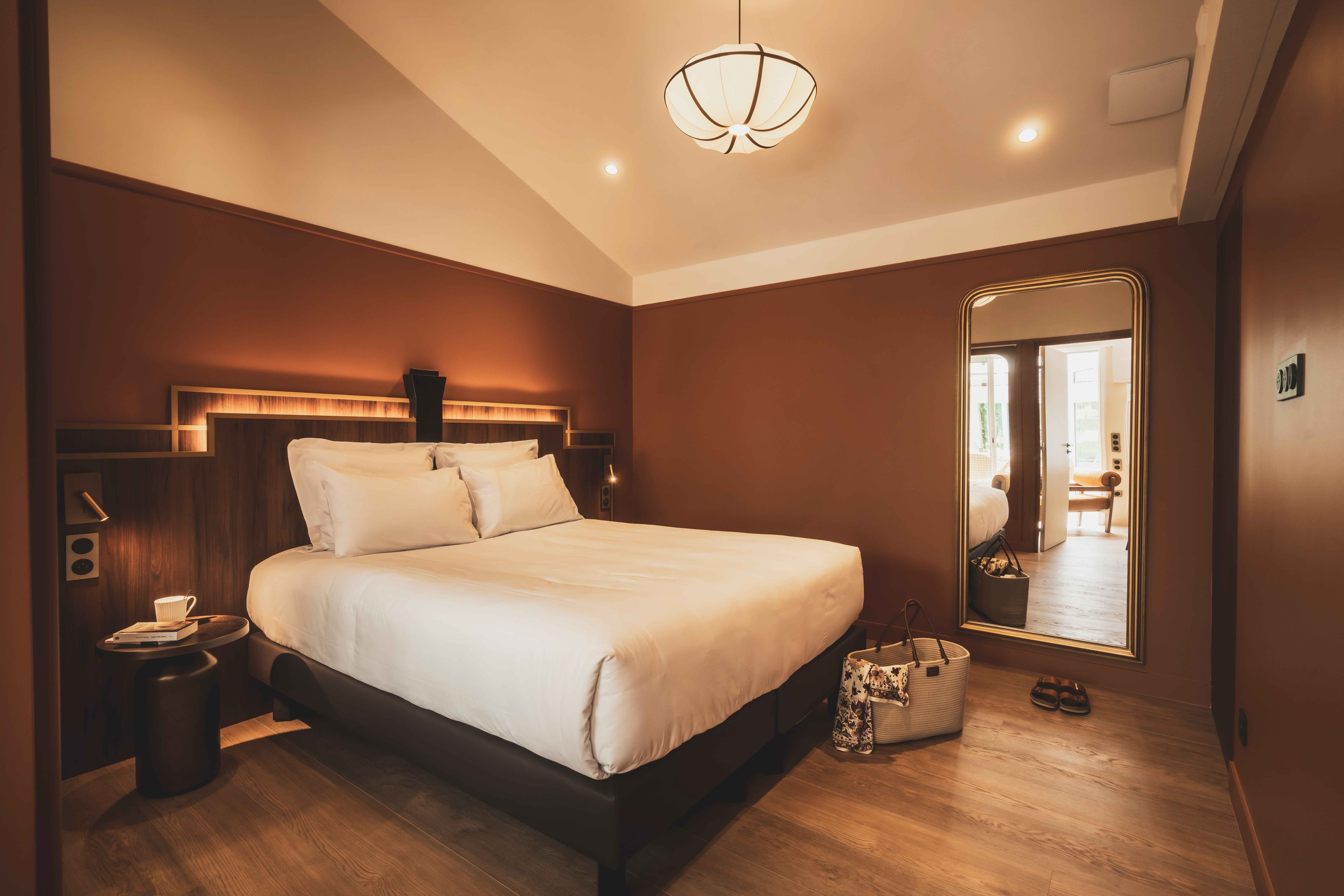 image A peaceful bedroom with warm colors and soft light, opening onto the greenery of the park.