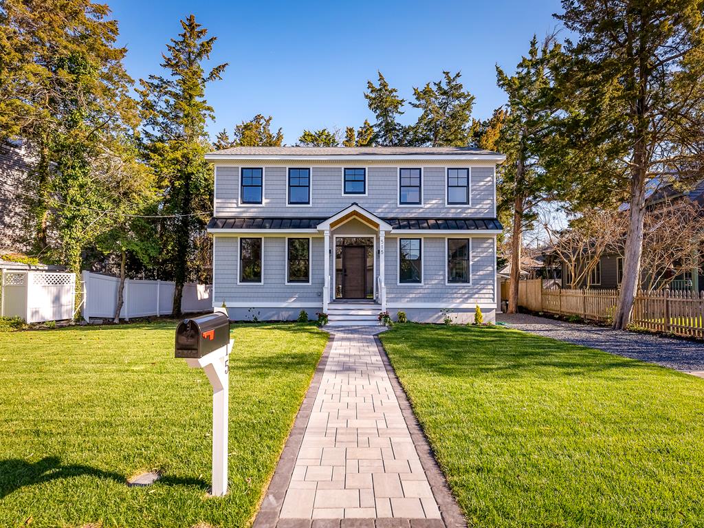 image Charming beachside retreat just steps from the sand, featuring a spacious front yard and classic coastal design.