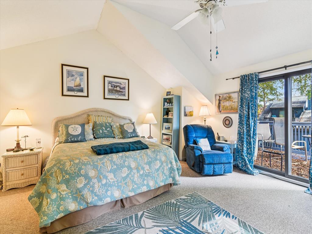 image Bedroom features a large bed with blue bedding, side tables, and a recliner near sliding doors to the patio