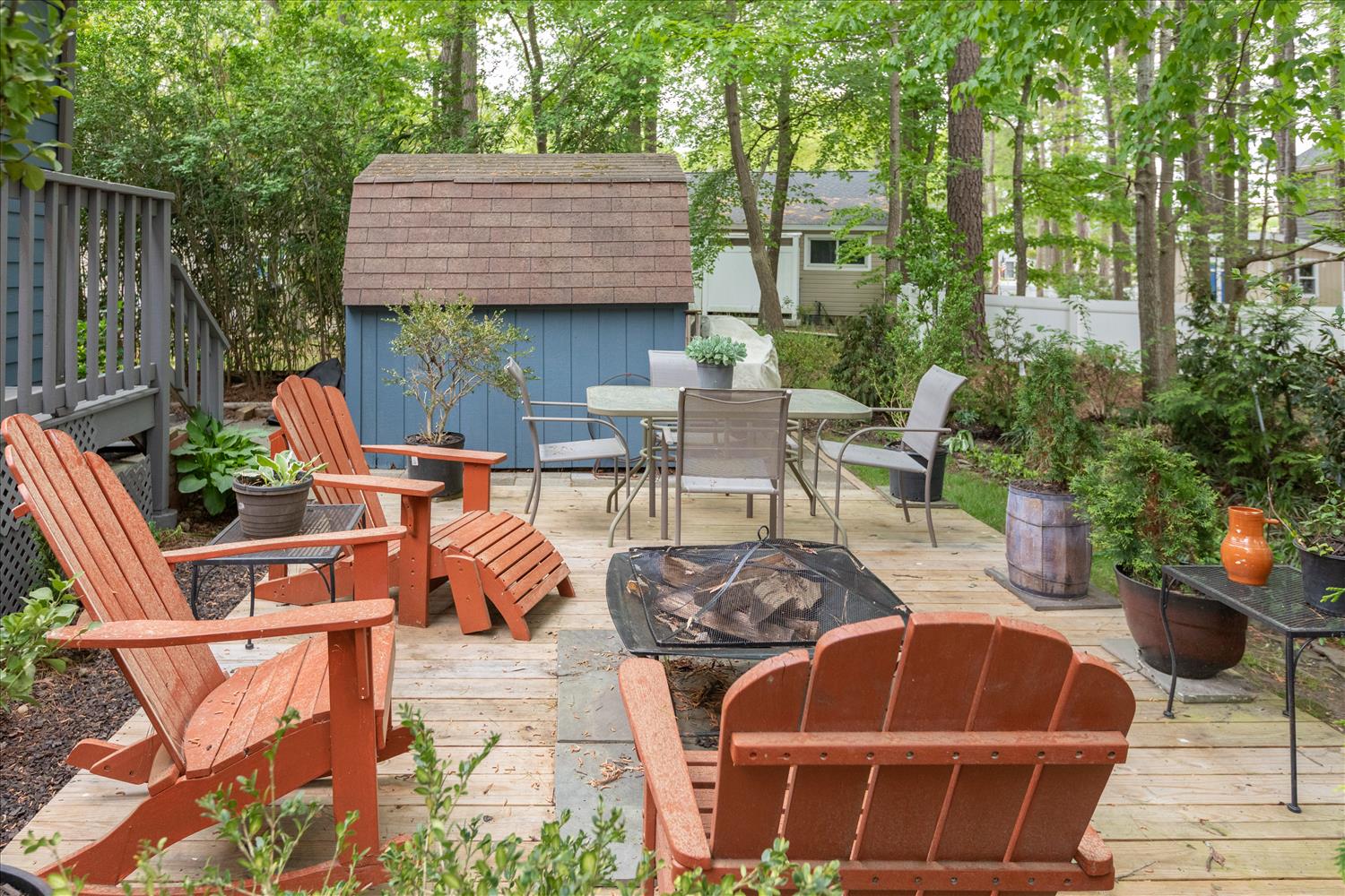 image Enjoy the outdoor seating area and firepit surrounded by greenery.