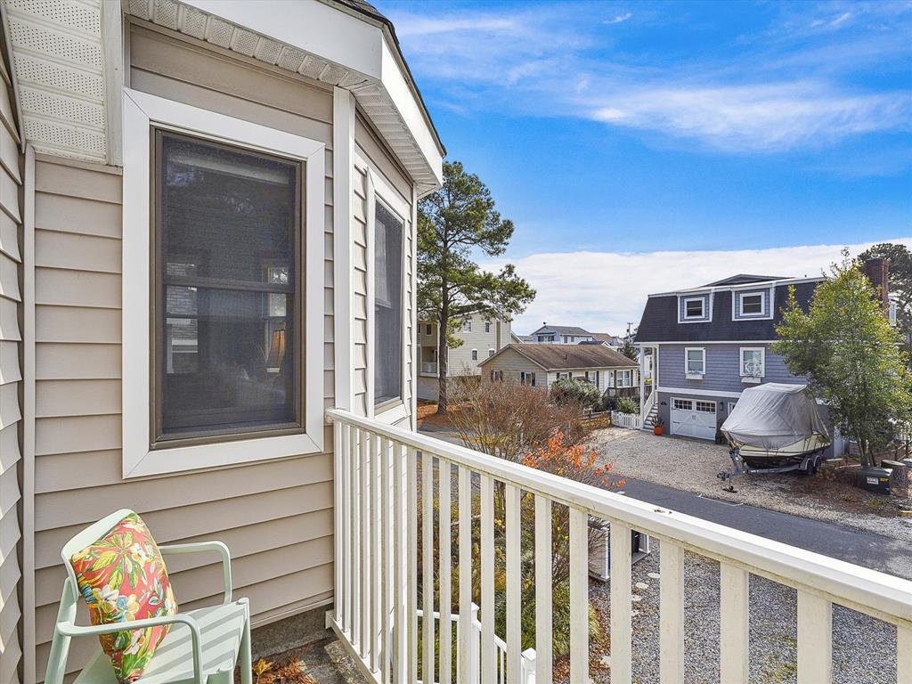 image A picturesque balcony view offering glimpses of neighboring homes and a tranquil outdoor setting, ideal for enjoying the fresh coastal air.