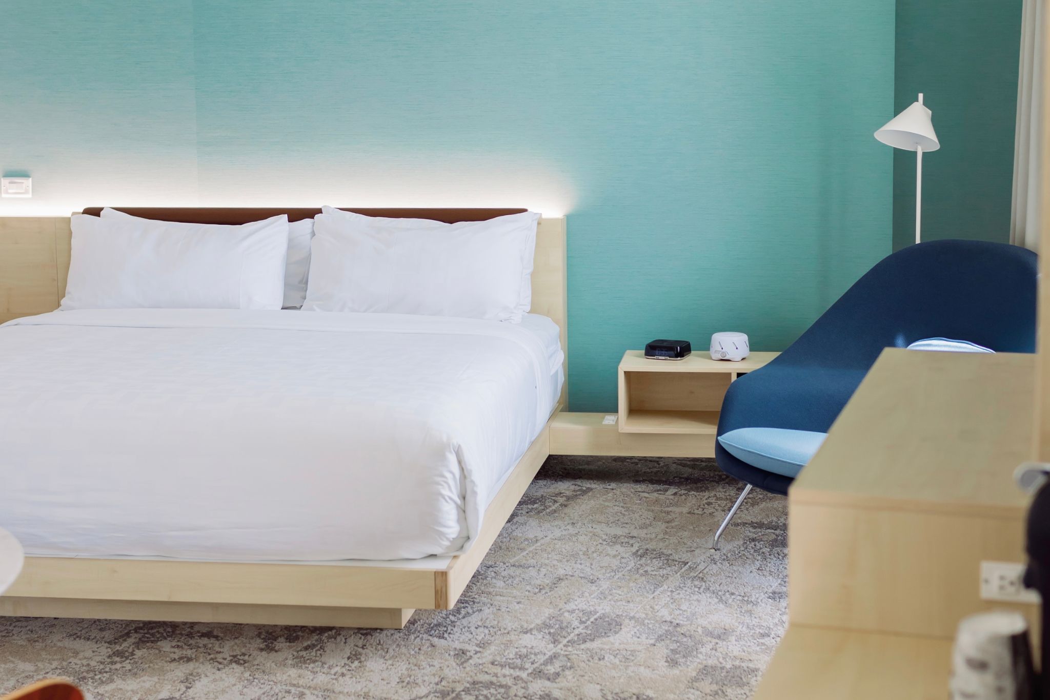 image Soft tones, crisp linens, and a sweeping city view define this refined king bedroom at Hotel Eleo.