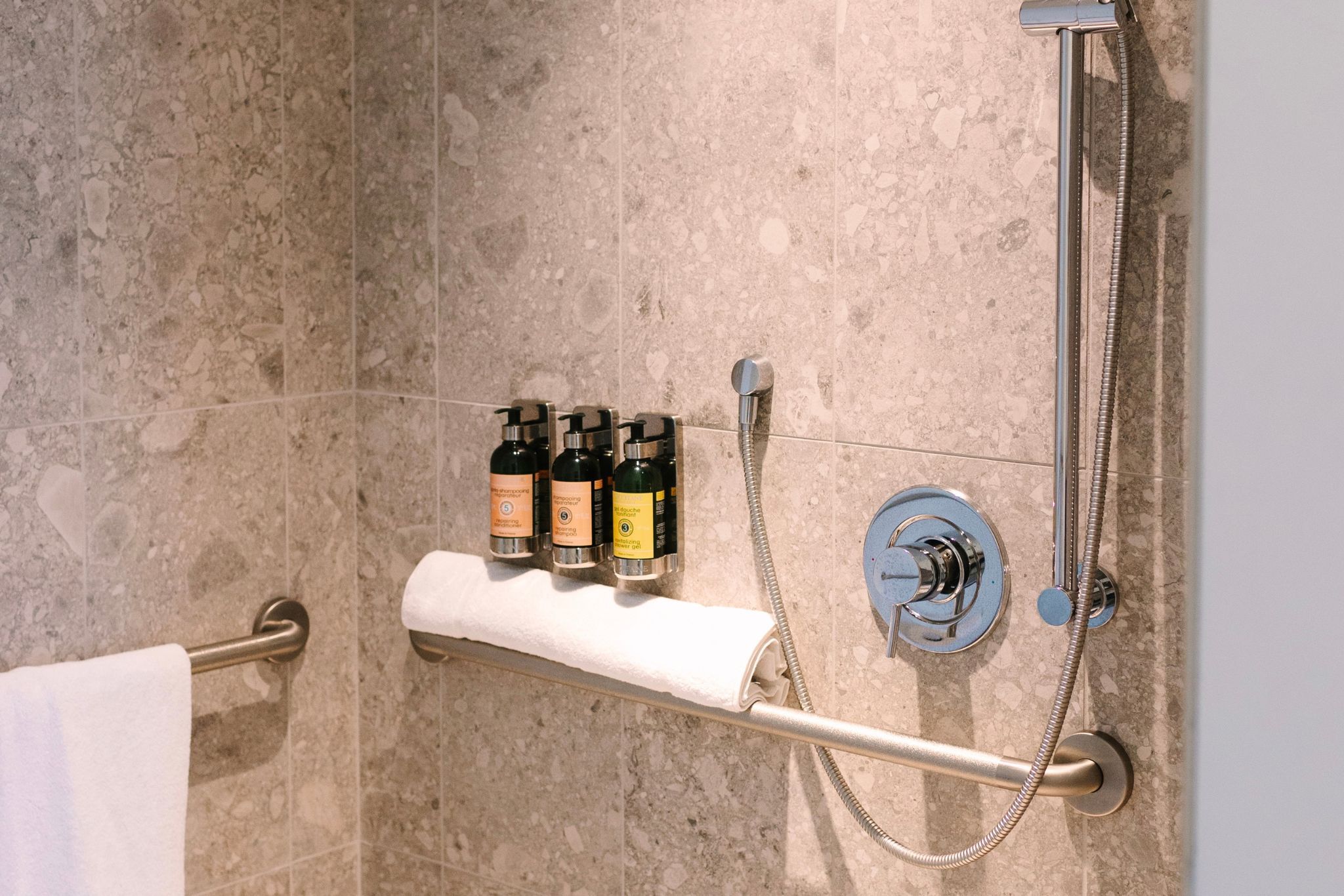 image Step into luxury with this ADA-accessible roll-in shower at Hotel Eleo, where modernity meets comfort just steps from the University of Florida.