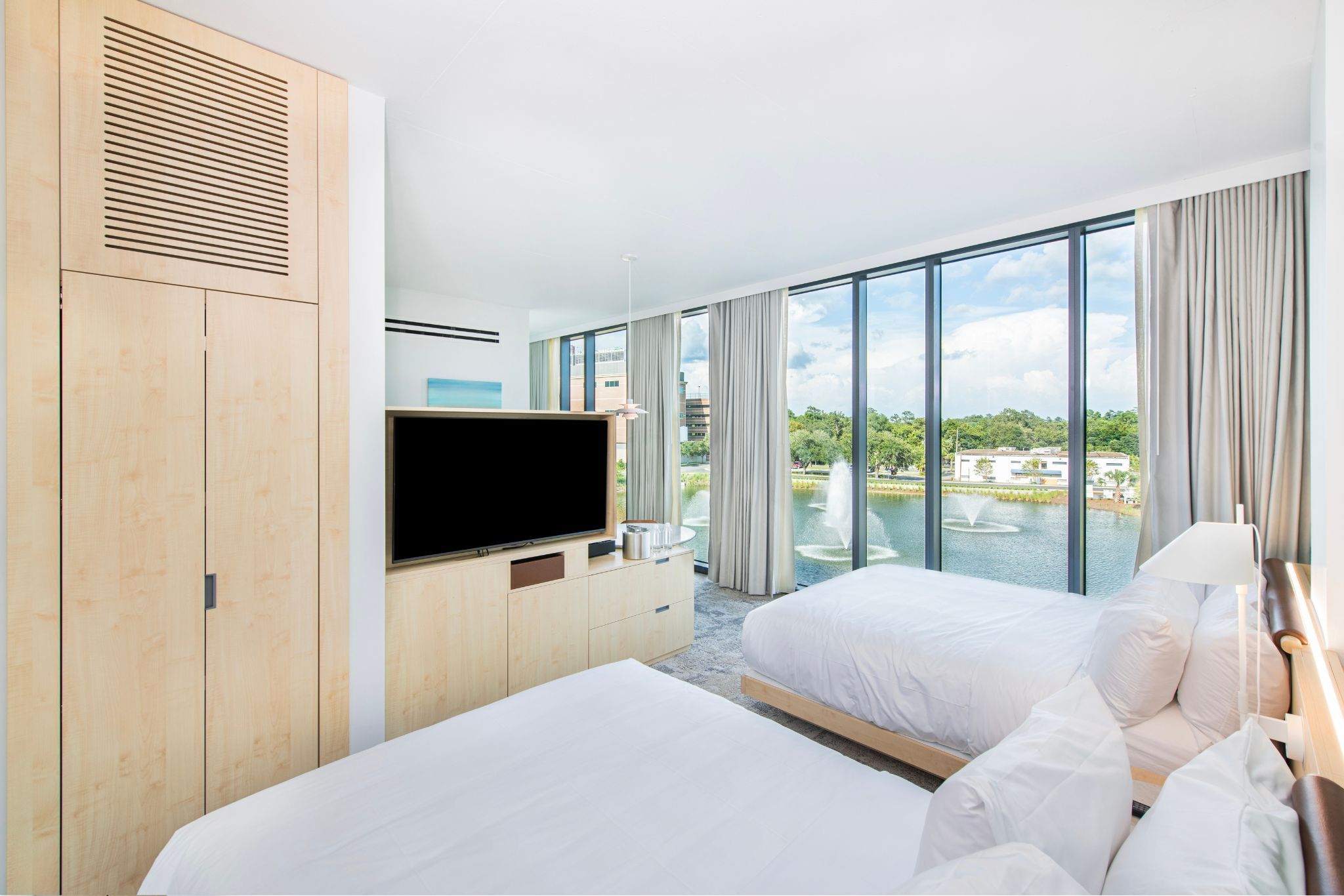 image This guestroom invites families to relax in refined comfort, all while enjoying captivating lake views through expansive windows.