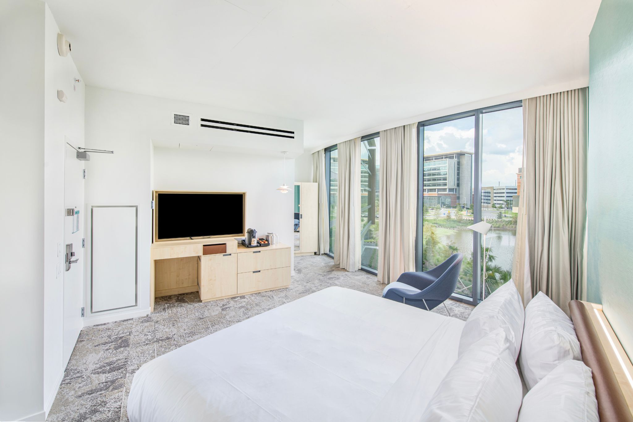 image Natural light pours into the spacious studio, highlighting a luxurious king bed and serene views of the tranquil lake.