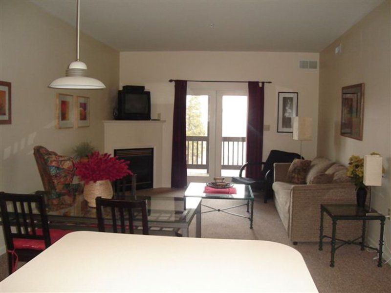 image Spacious living area with a fireplace, dining space, and private balcony access — perfect for unwinding after a day on the slopes.