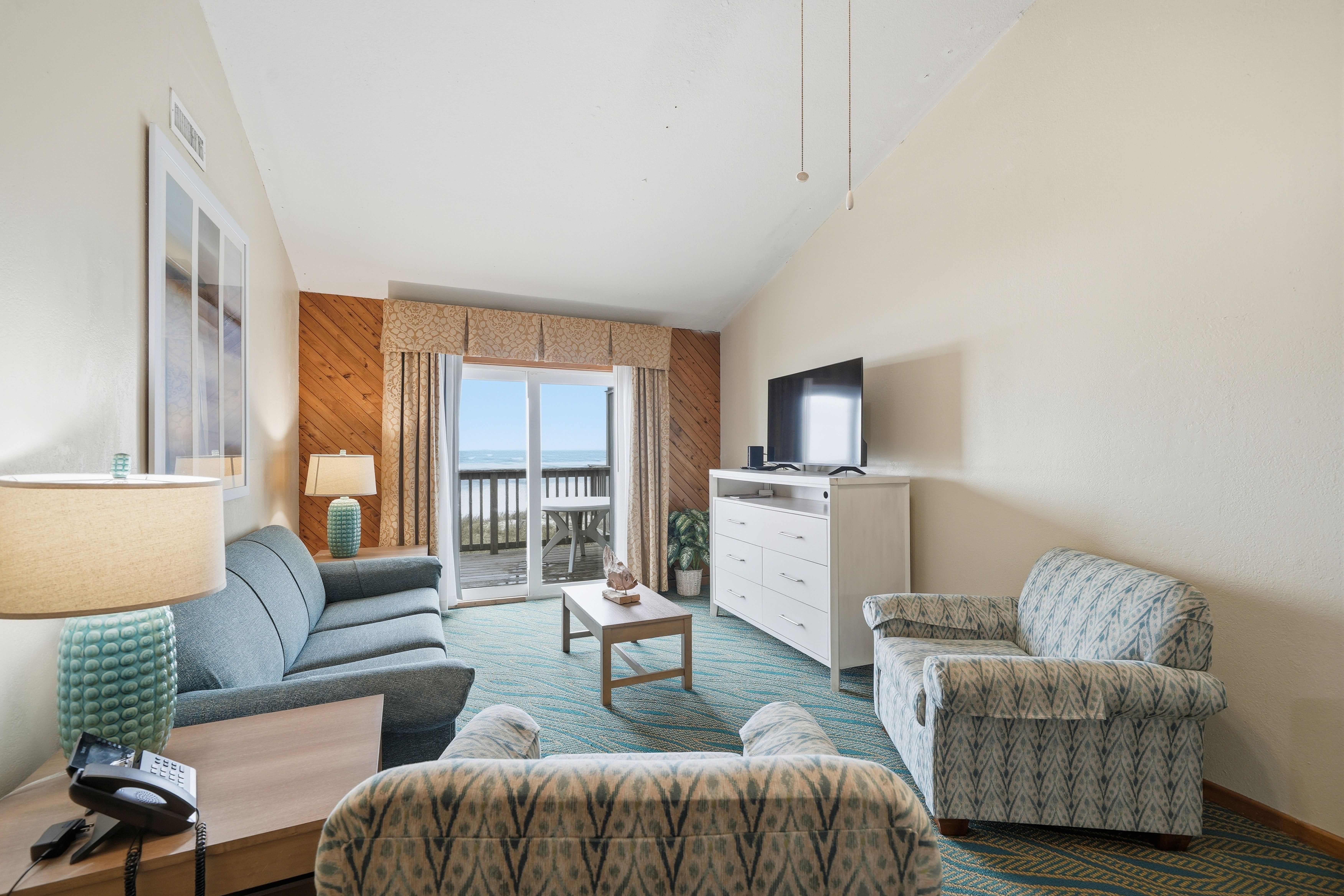 image Enjoy ocean breezes in this welcoming space, with large windows providing a picturesque view of the coast.