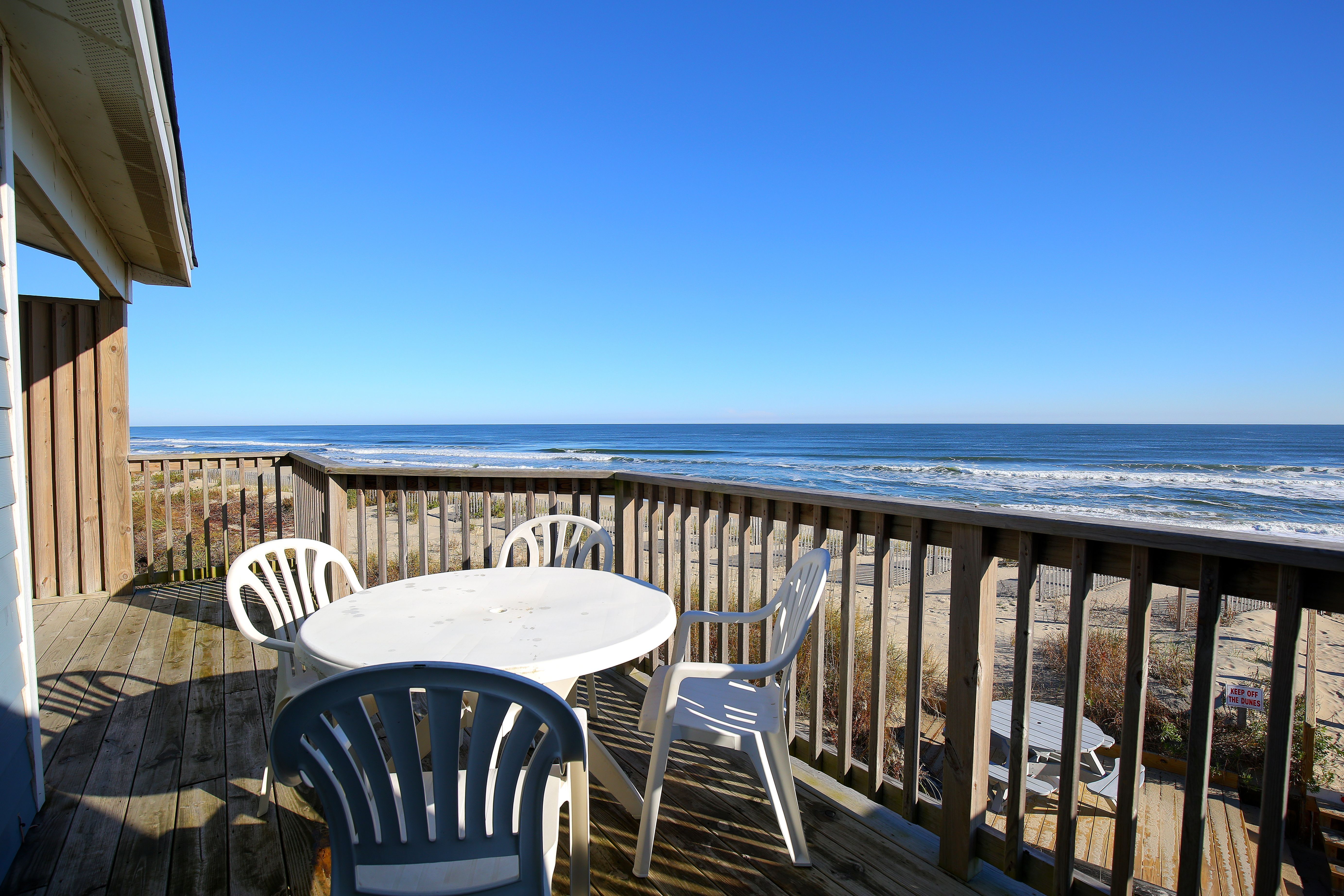 image Enjoy breathtaking oceanfront views from the spacious balcony, complete with a dining table perfect for morning coffee in Duck, North Carolina.